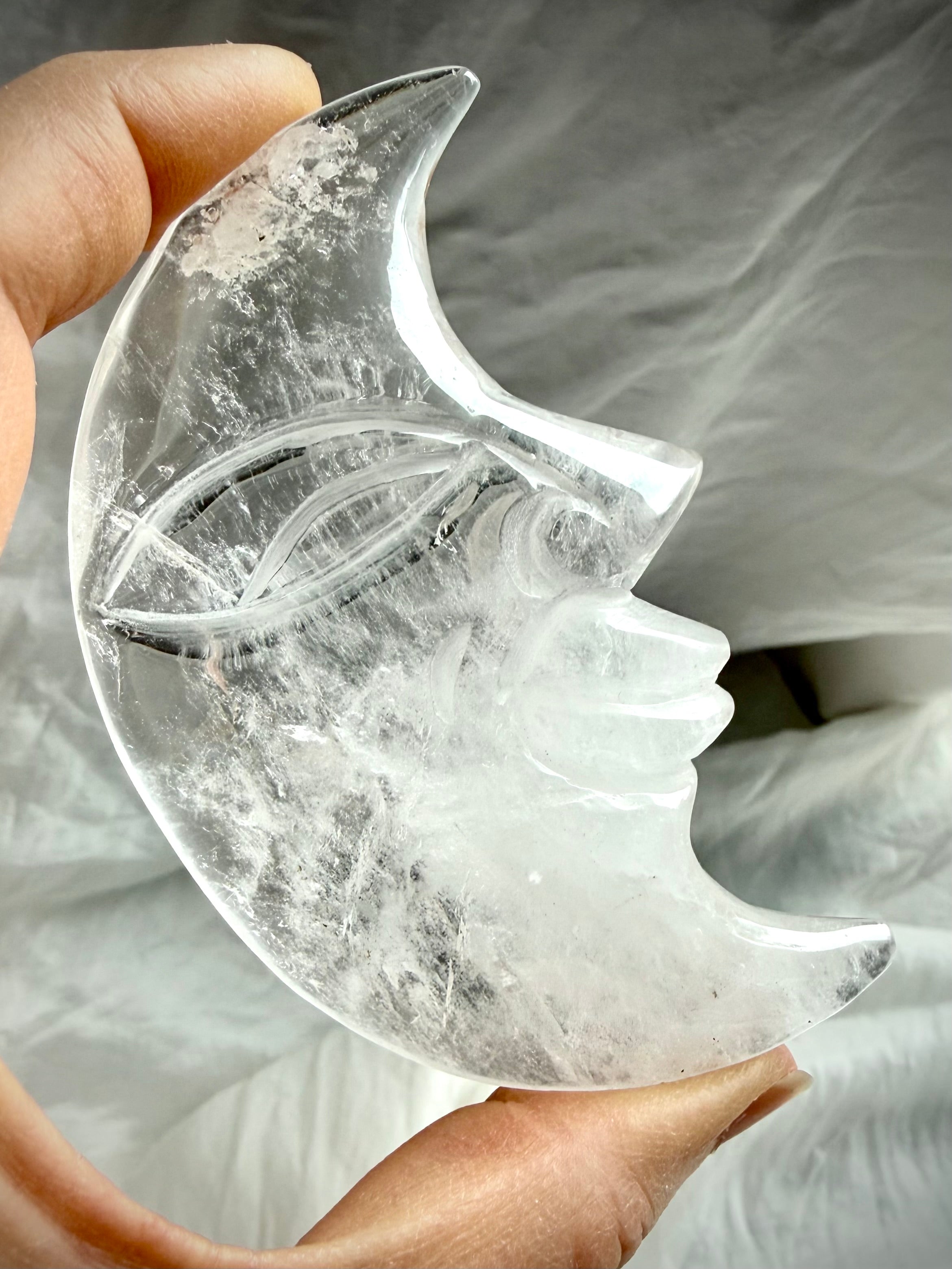Reverse side of Clear Quartz Moon Face carving showing intricate carving, polished finish, and exceptional crystal clarity