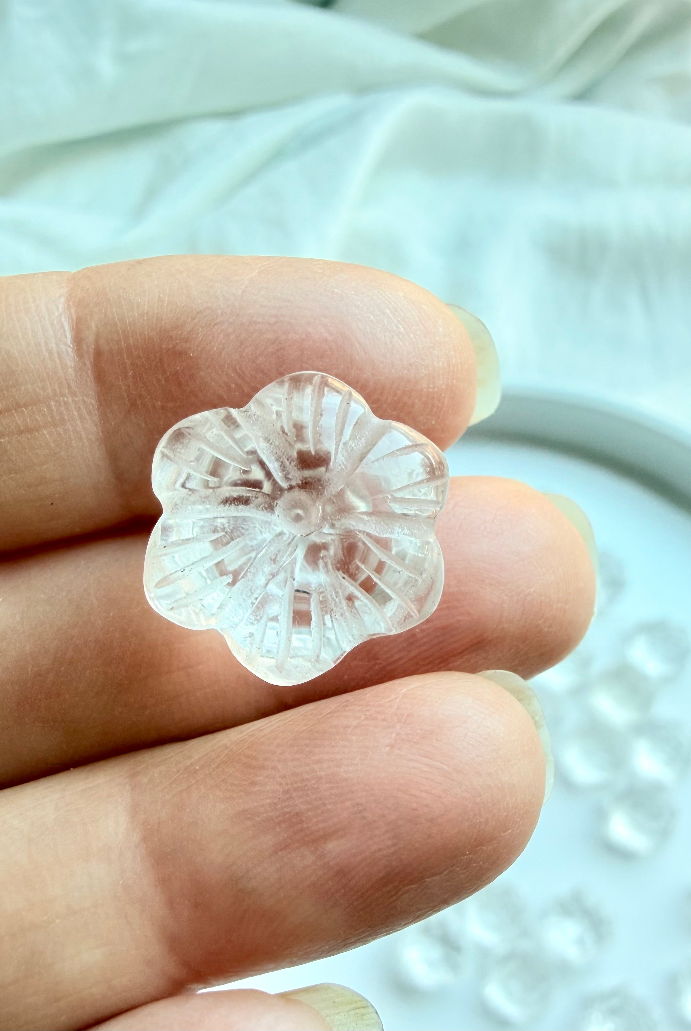 Mini Clear Quartz lotus crystal flower held in hand showing the underside detailed hand-carved petals and transparent quartz