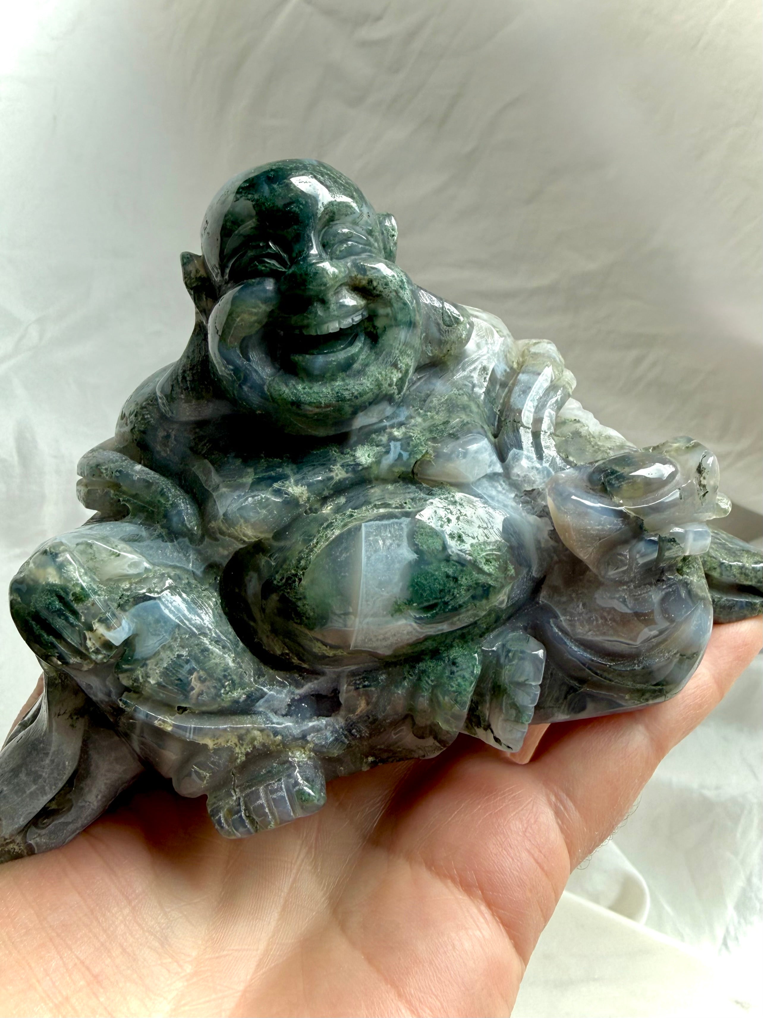 Large Moss Agate Laughing Buddha statue held in hand showing size and polished details
