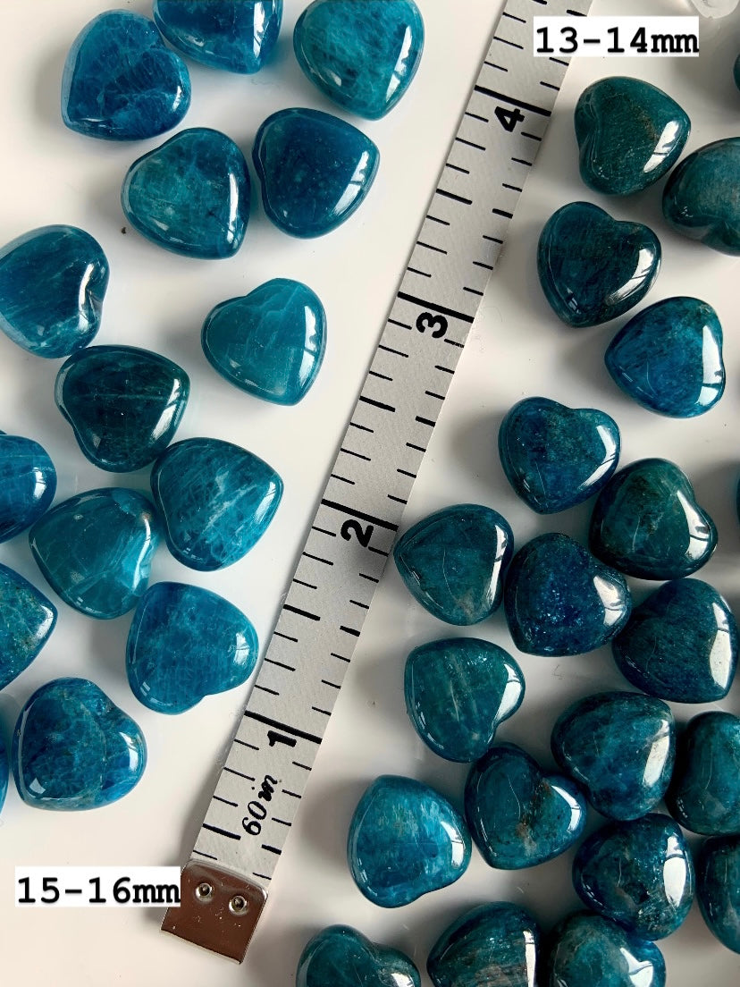 Blue Apatite heart stones displayed with measuring tape for scale, small polished crystal hearts for pocket stones and crystal grids