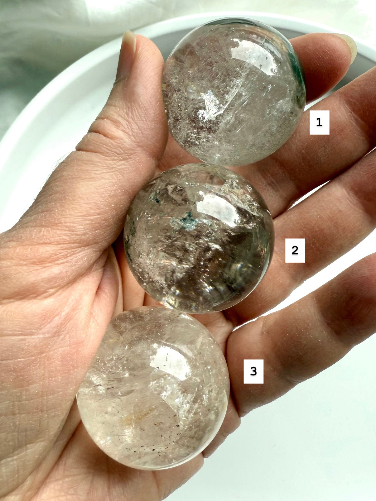 three garden quartz crystal spheres in hand – lodolite spheres for grounding energy and meditation
