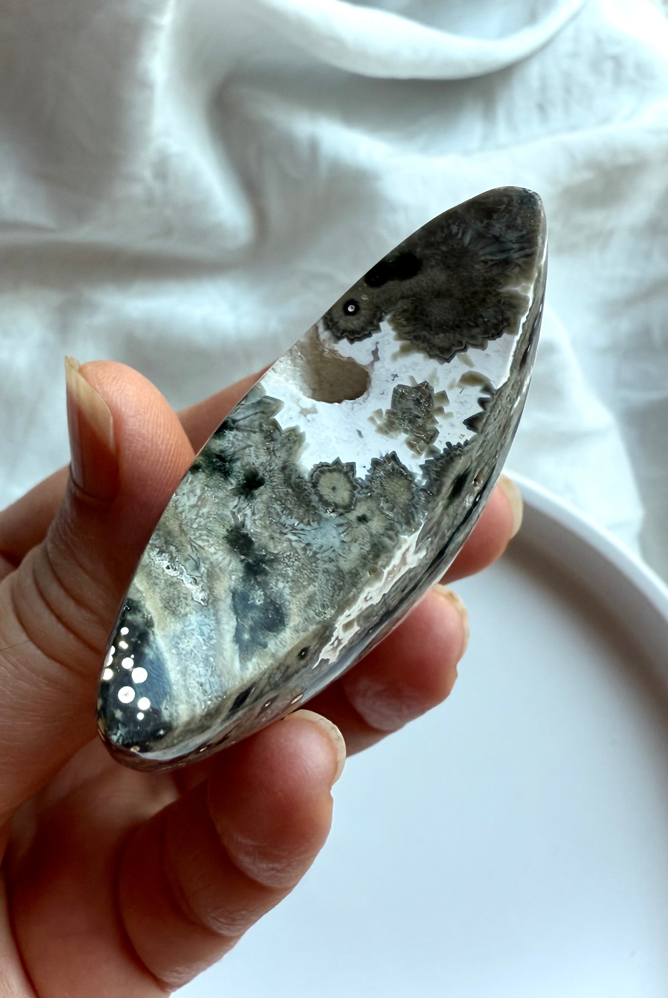 Ocean Jasper crescent moon palm stone in gray and black starburst patterns for grounding, strength, and inner healing