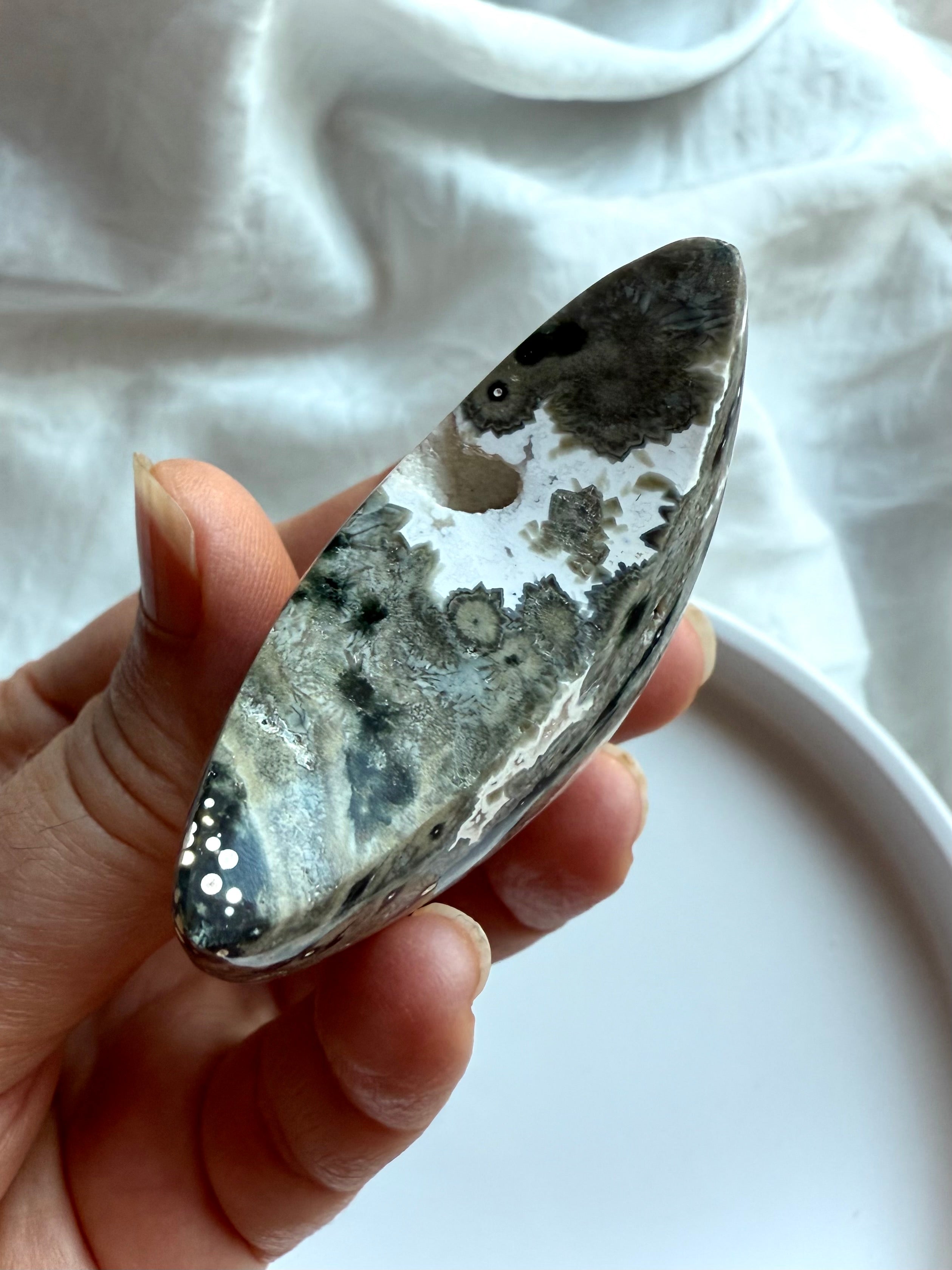 Ocean Jasper crescent moon palm stone in gray and black starburst patterns for grounding, strength, and inner healing