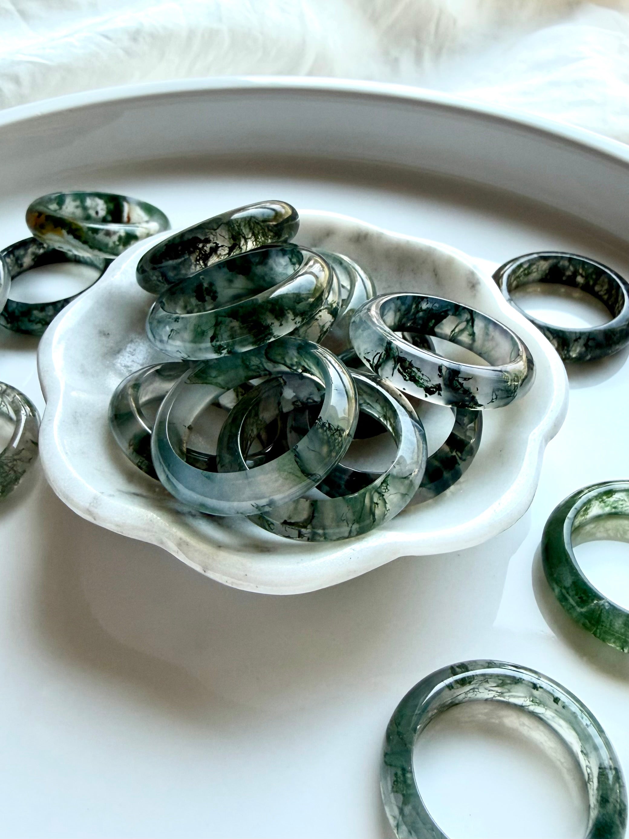 moss agate band rings styled together showing natural dendritic inclusions and polished shine, grounding crystal rings for everyday wear
