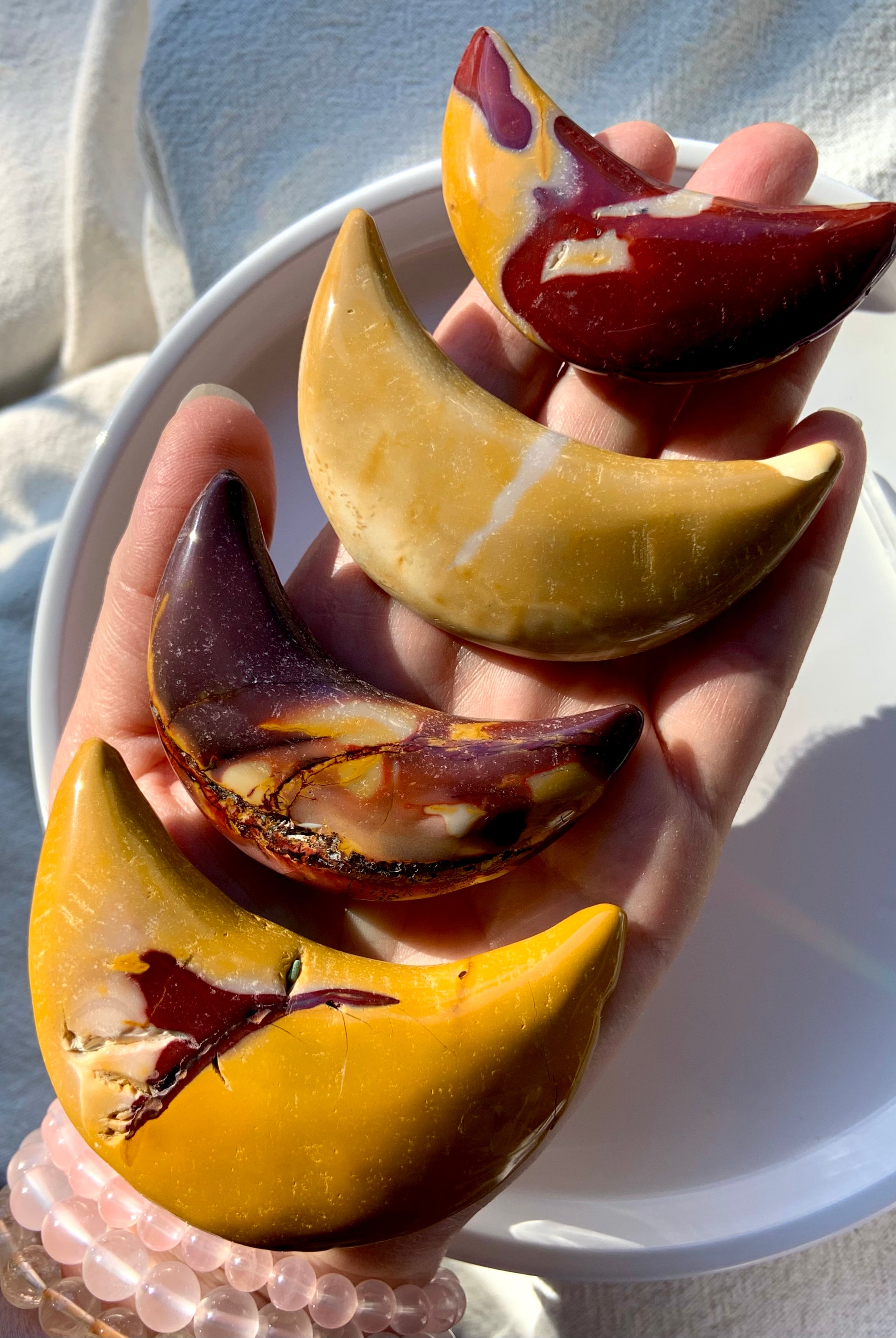 Big, colorful Mookaite Jasper Crescent Moon Carvings shown on my hand for scale. Choose your favorite from the dropdown menu.