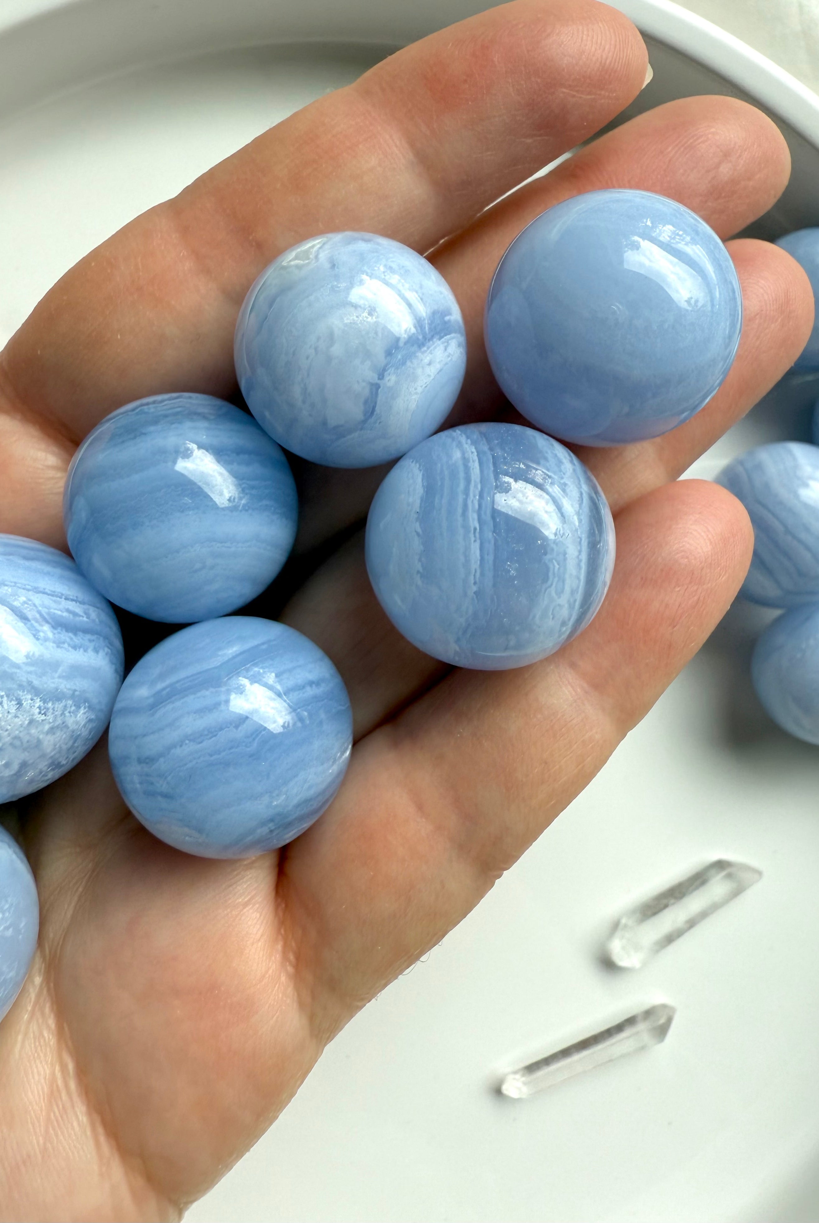 High quality mini Blue Lace Agate Spheres shown on my hand for scale