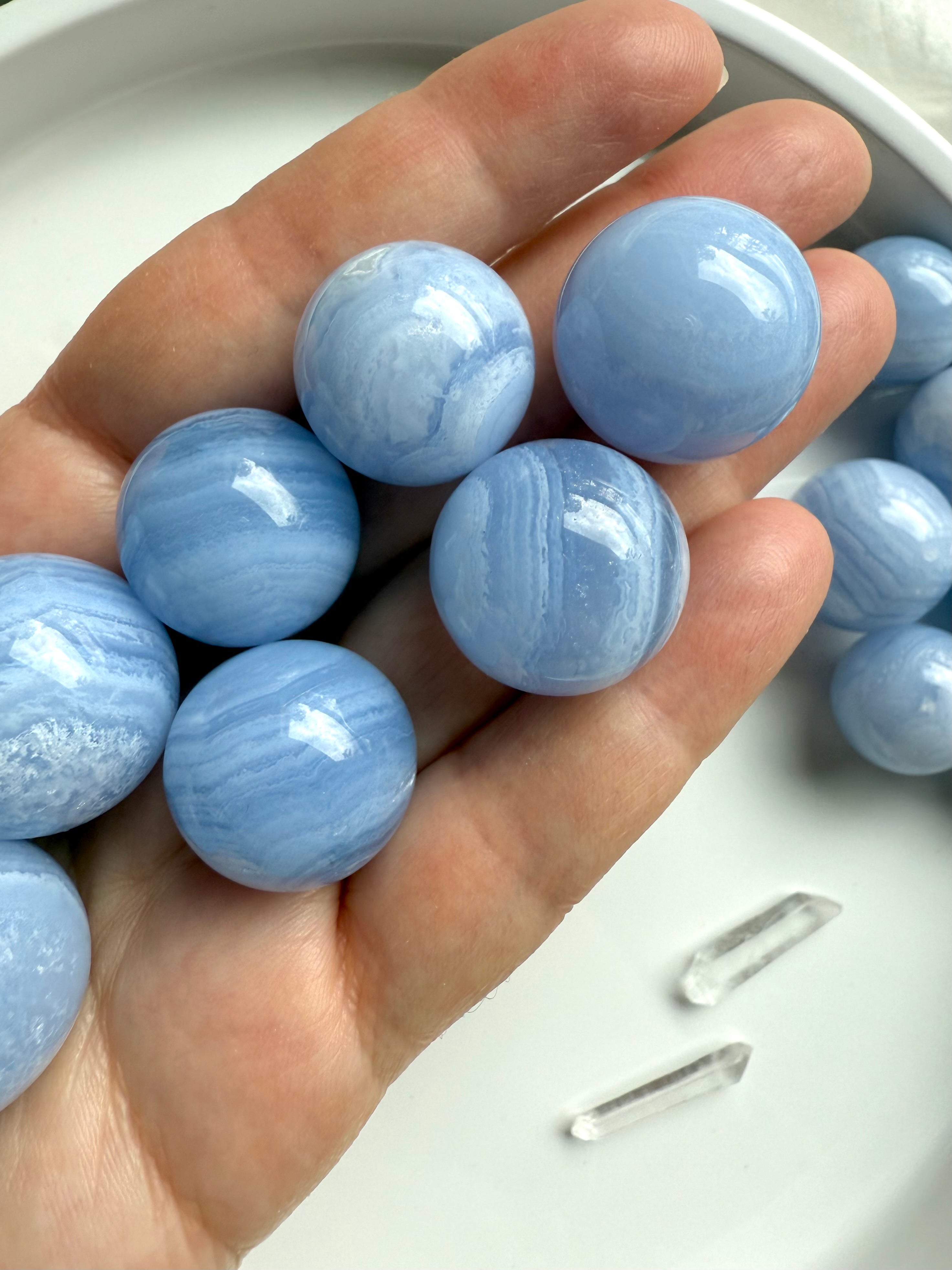 High quality mini Blue Lace Agate Spheres shown on my hand for scale