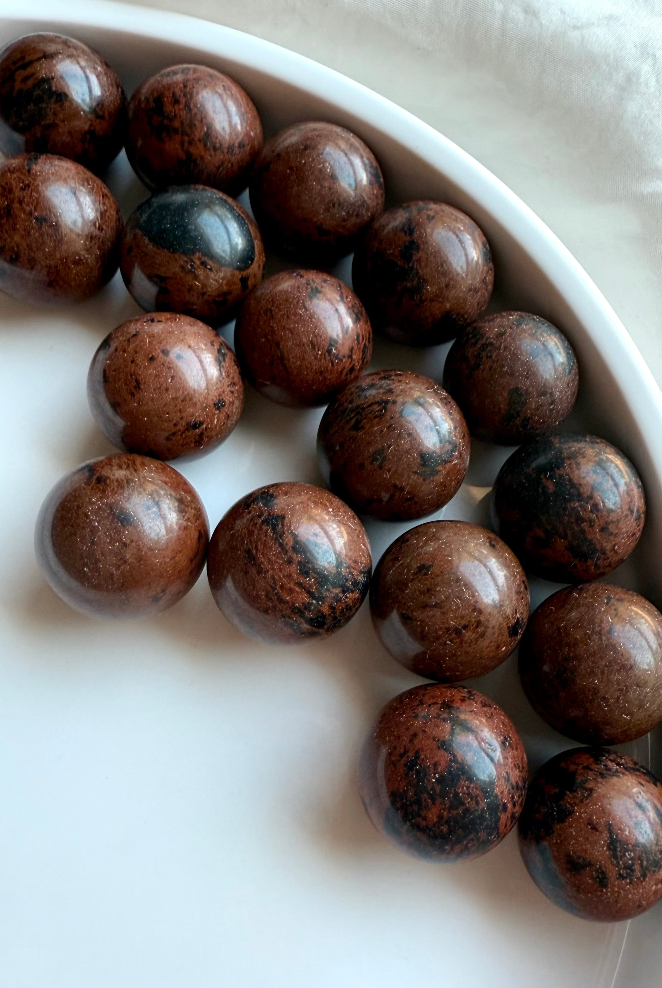 Array of Mahogany Obsidian mini spheres with rich brown and black patterns – crystals for protection and strength