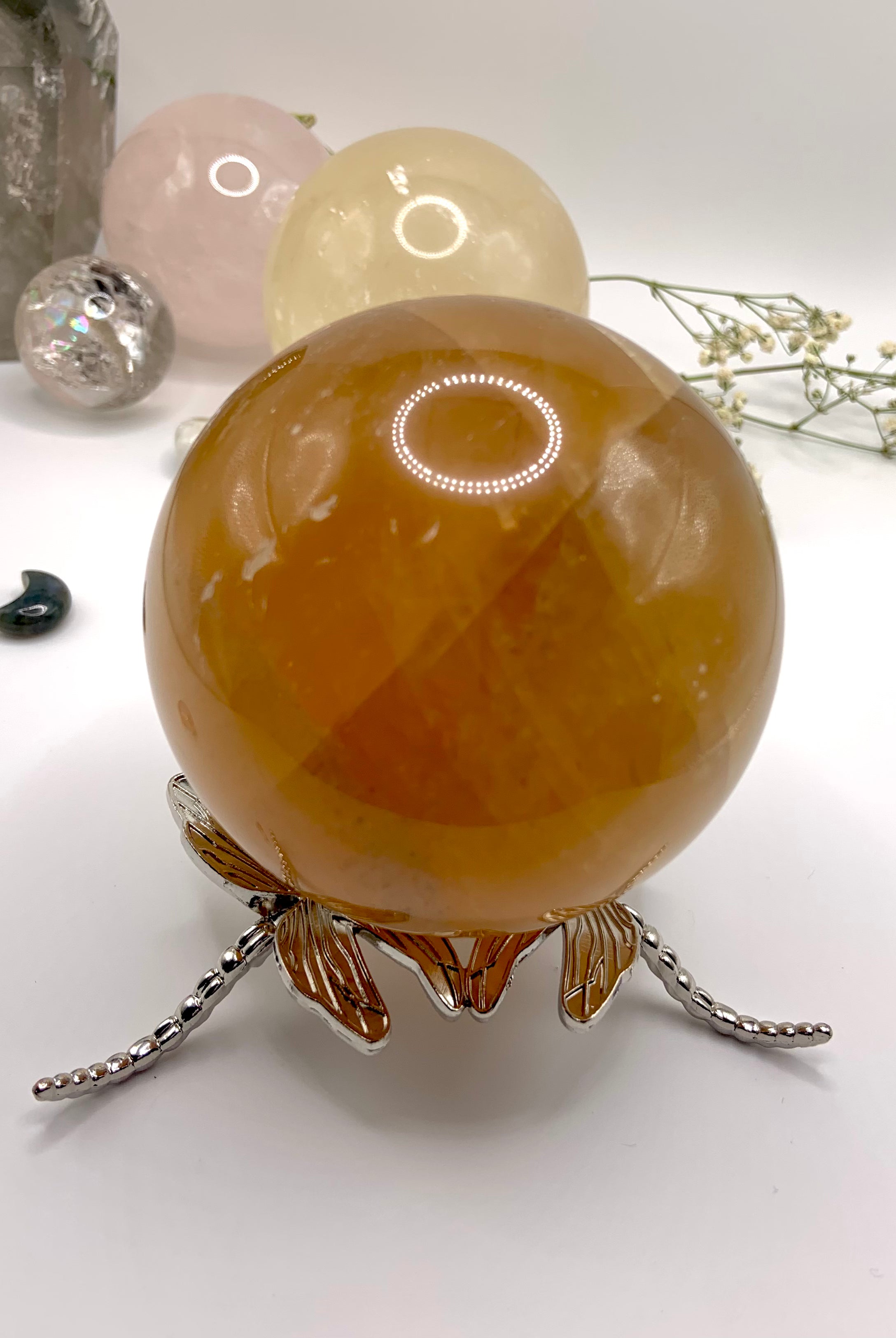 The larger dragonfly crystal ball stand shown with a 80mm honey calcite sphere