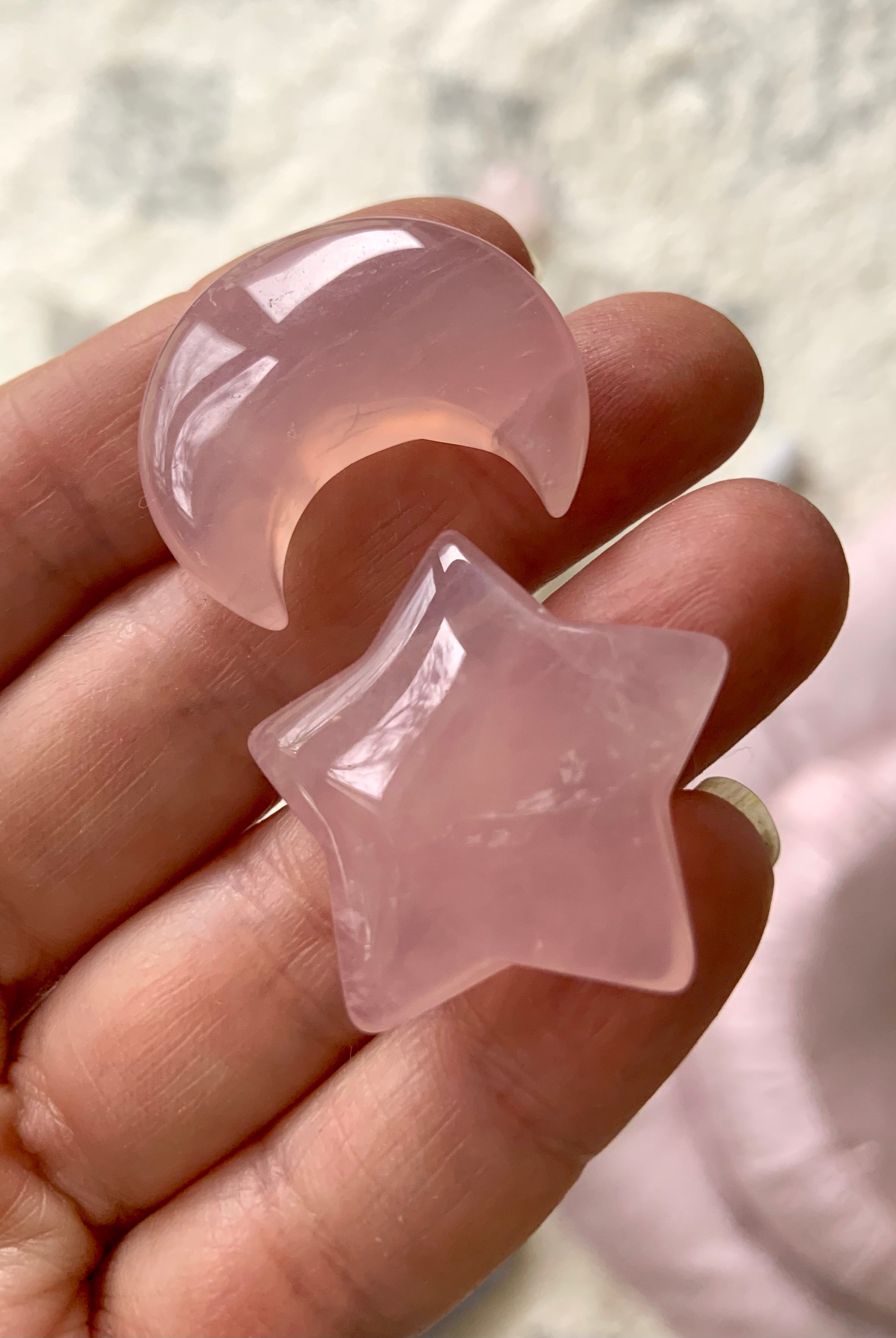 Close-up of Rose quartz moon and star crystals shown in hand for scale. Heart Chakra stones perfect for meditation or gifting.