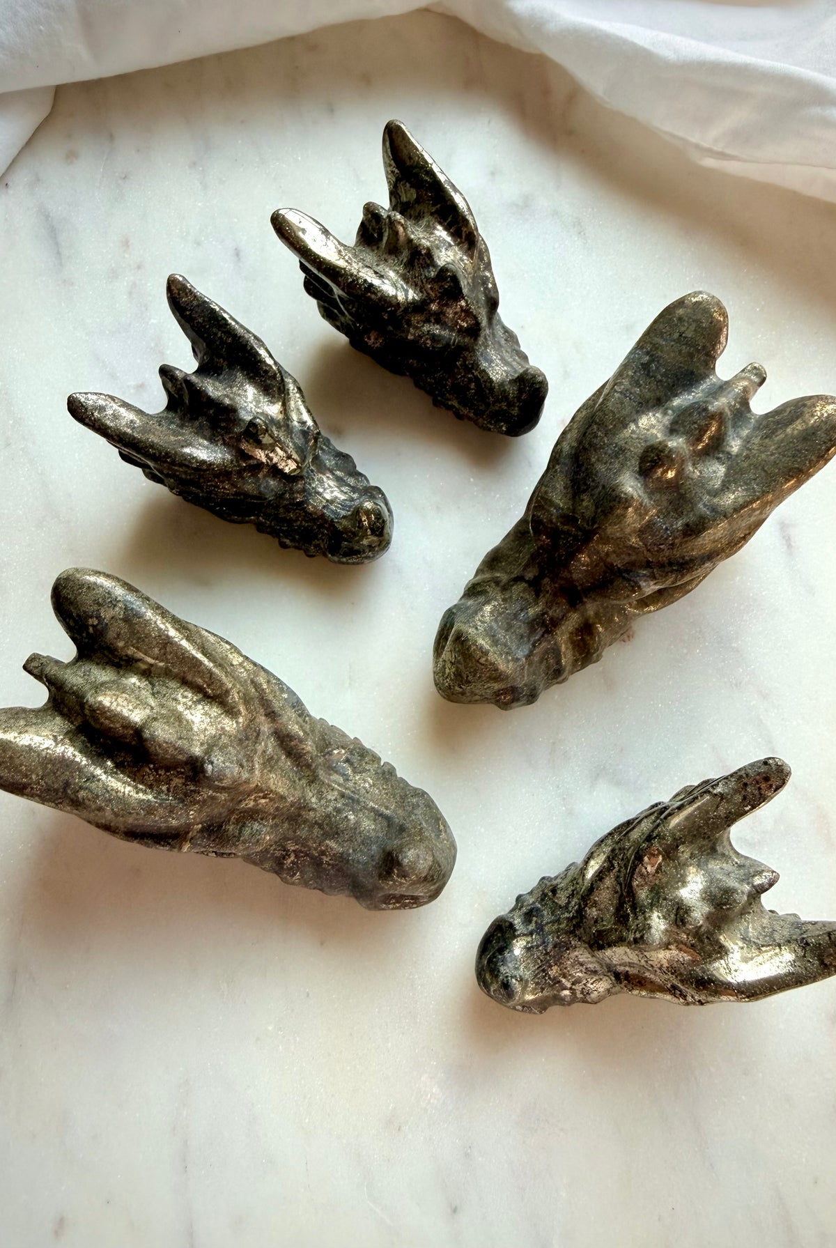 Assorted Pyrite dragon carvings in small and large sizes, featuring antiqued metallic surfaces and intricate dragon head designs