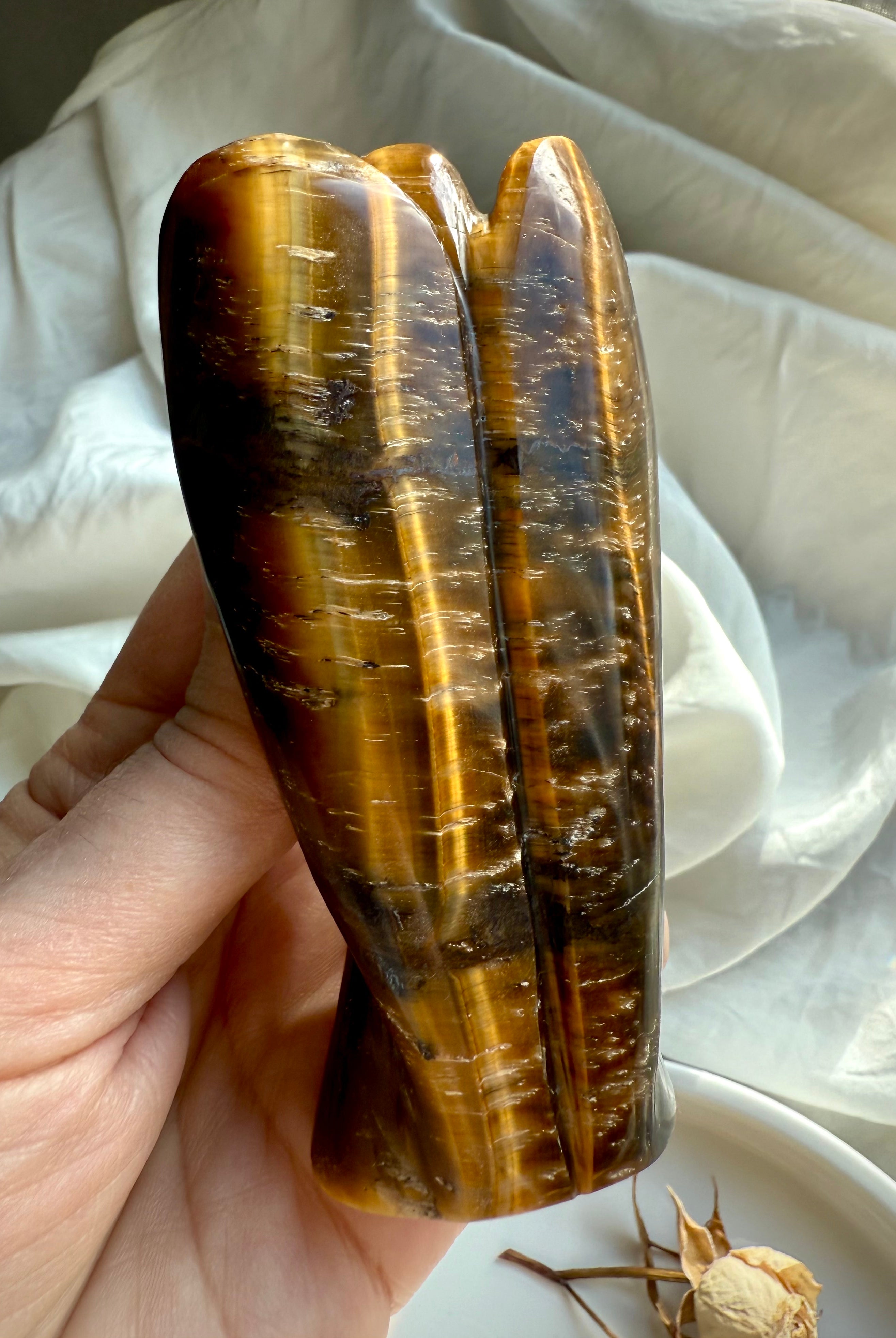 Back view of hand-carved Tiger’s Eye angel showing natural golden bands and reflective sheen
