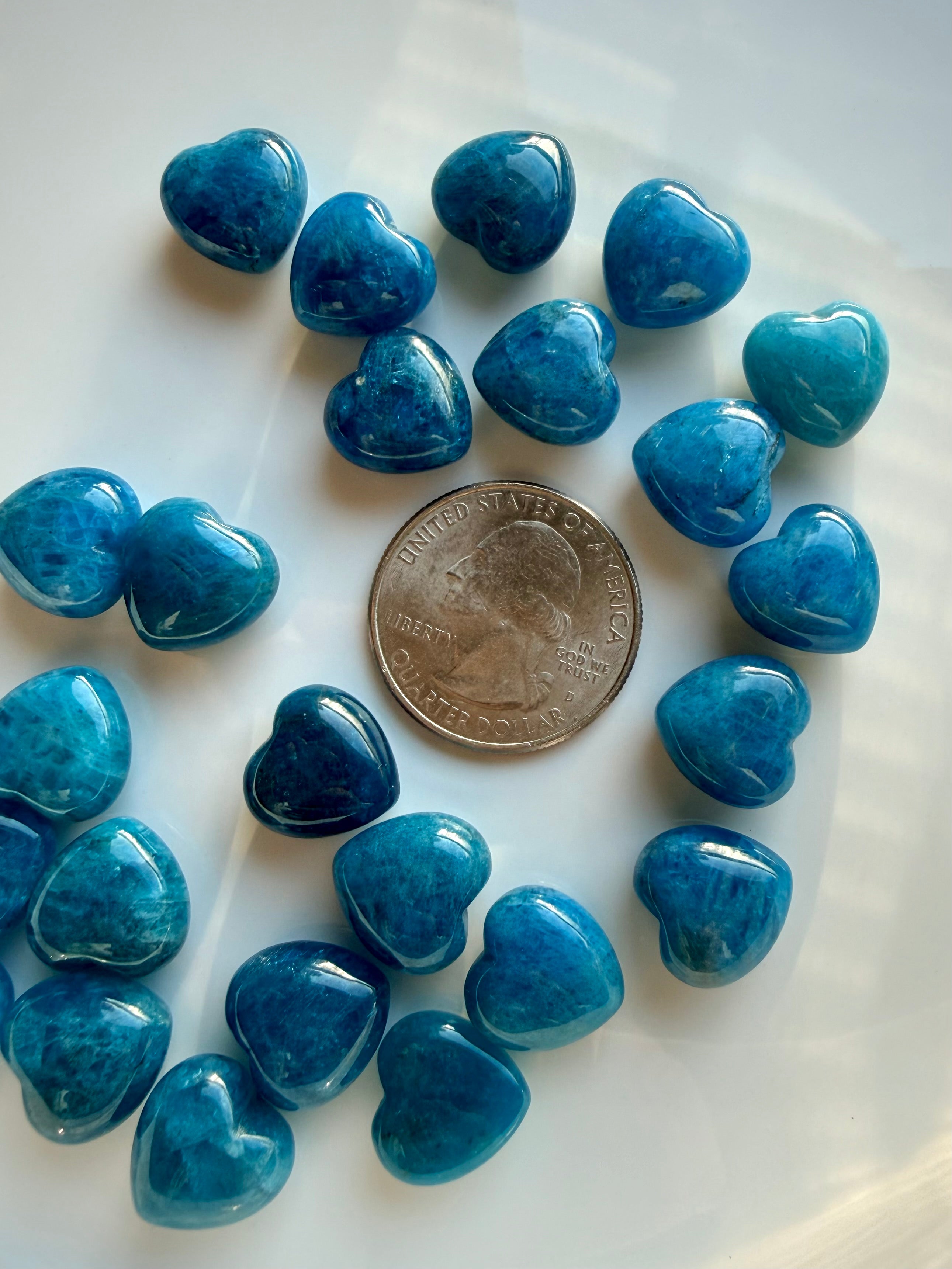 Mini Blue Apatite heart crystals shown beside US quarter for size reference, polished blue crystal hearts