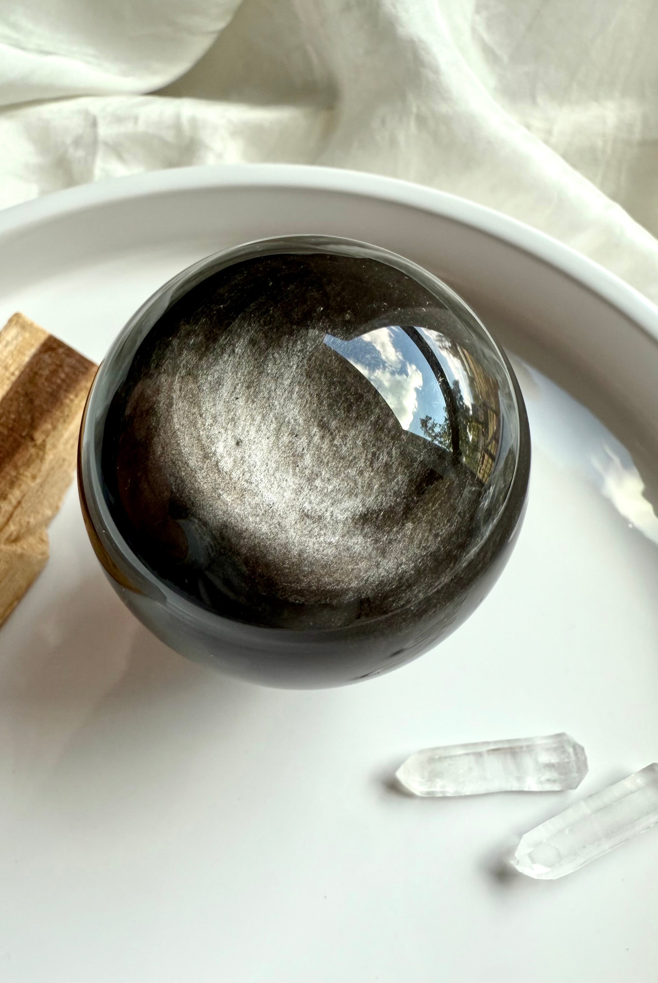 Altar display of Silver Sheen Obsidian sphere showing metallic silver sheen and swirling energy patterns