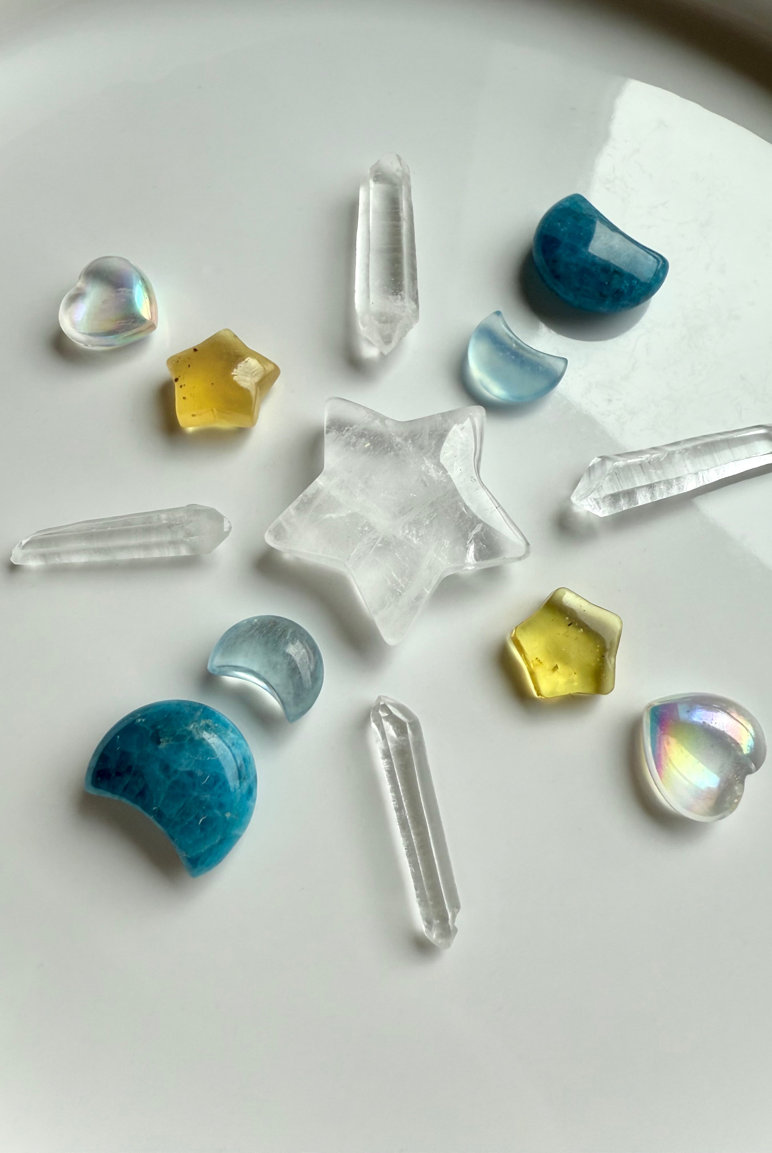 Mini aura quartz hearts arranged in a crystal grid with blue apatite moons, amber stars, and Lemurian points for angelic energy and light