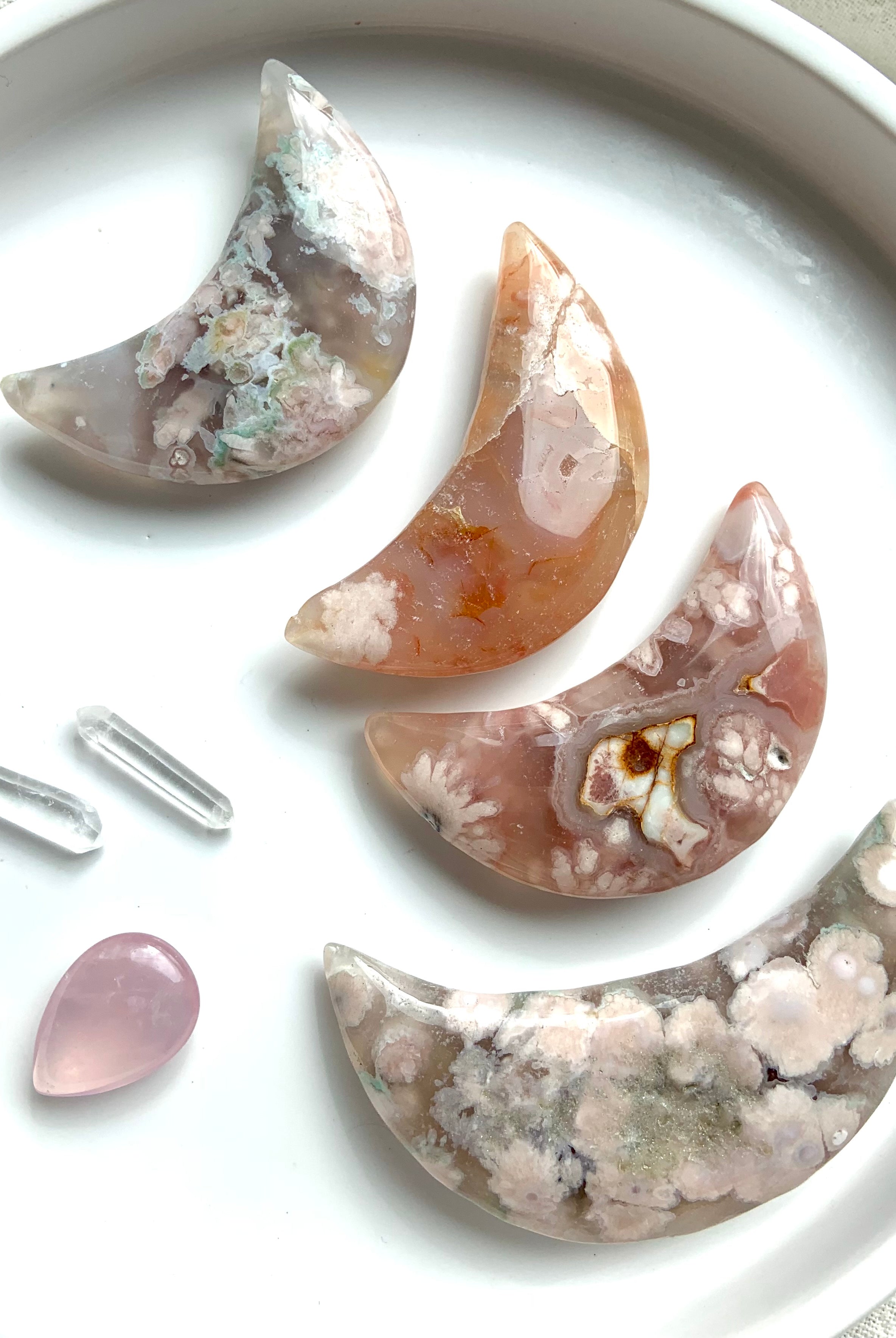 Big, palm sized Flower Agate Moons shown on a white plate with some smaller crystals. Choose your favorite!