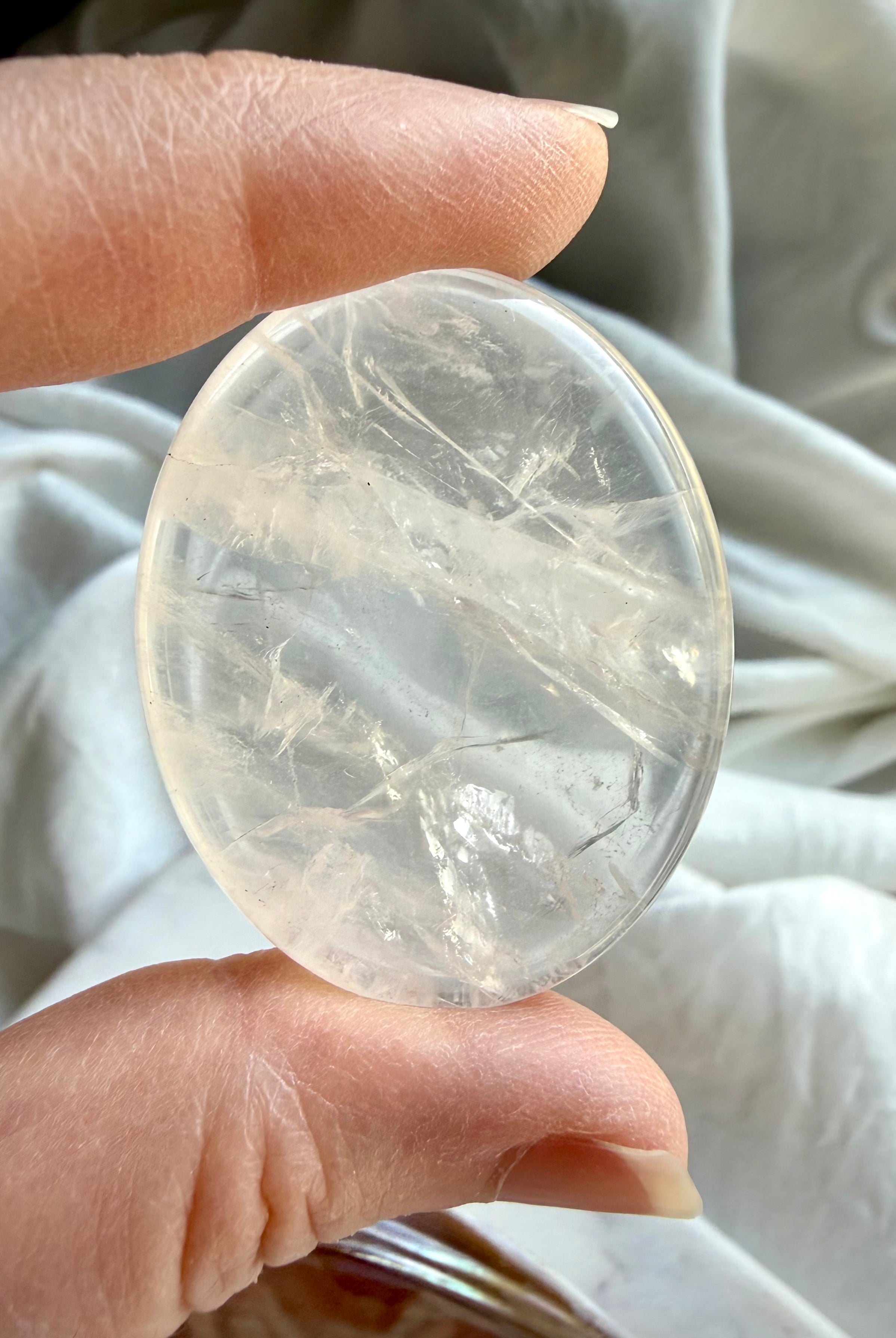 clear quartz palm stone close up showing internal inclusions for clarity and energy amplification