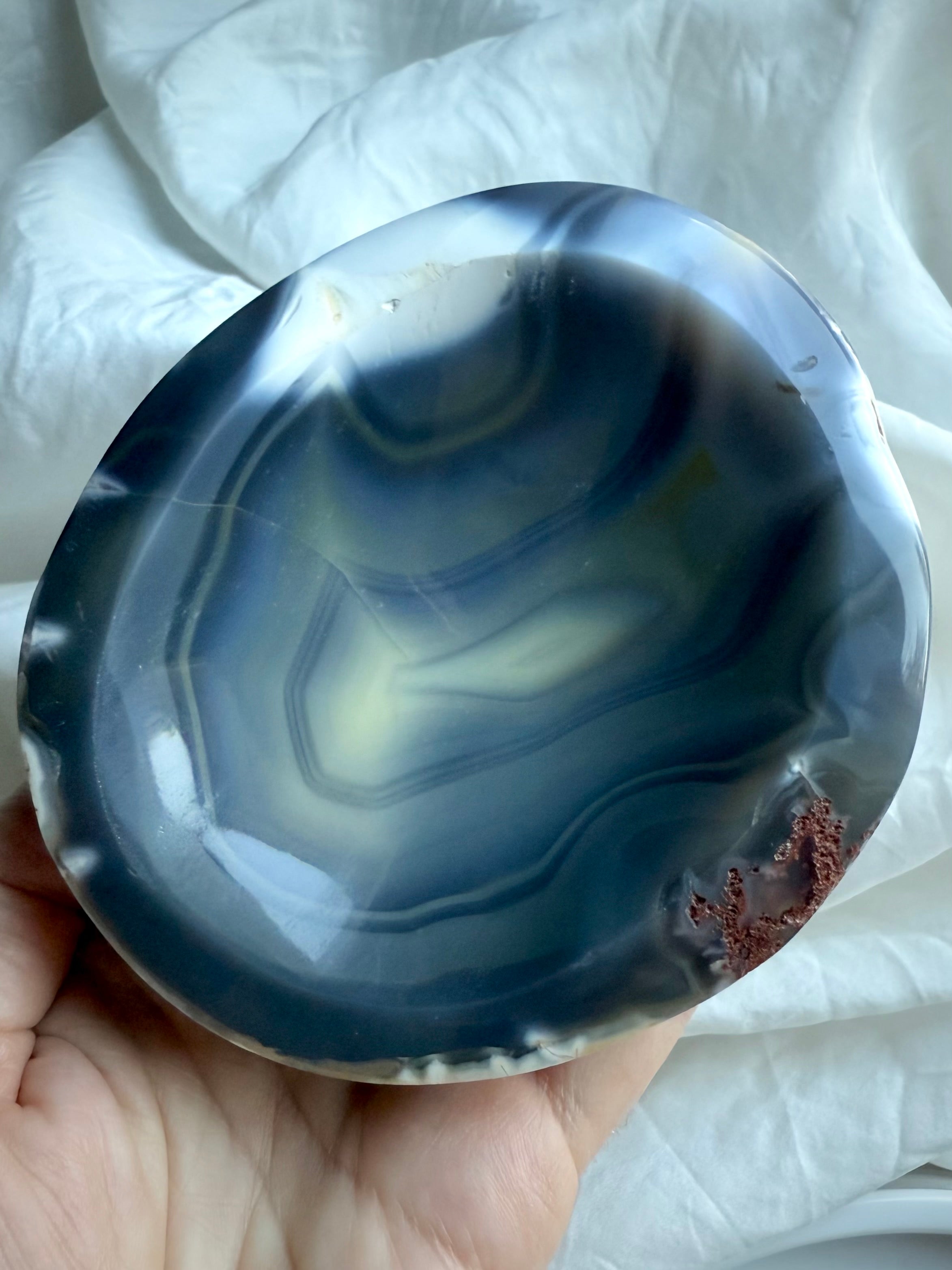 Orca Agate offering bowl with swirling gray, blue, and white banding held in hand — hand-carved crystal bowl for calm, grounding, and ritual work.