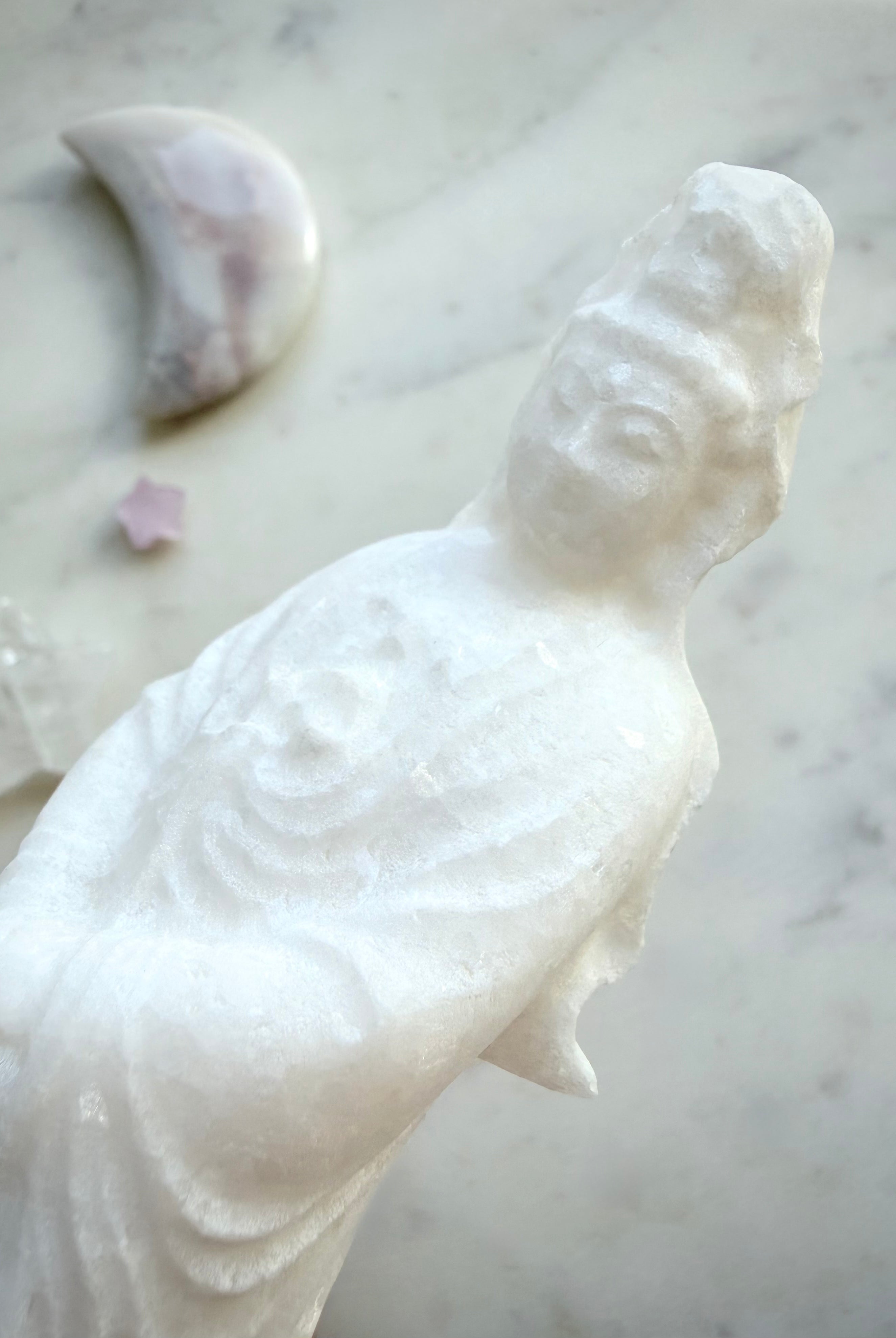 Detailed view of White Jade Goddess of Mercy carving with soft sparkle and elegant drapery