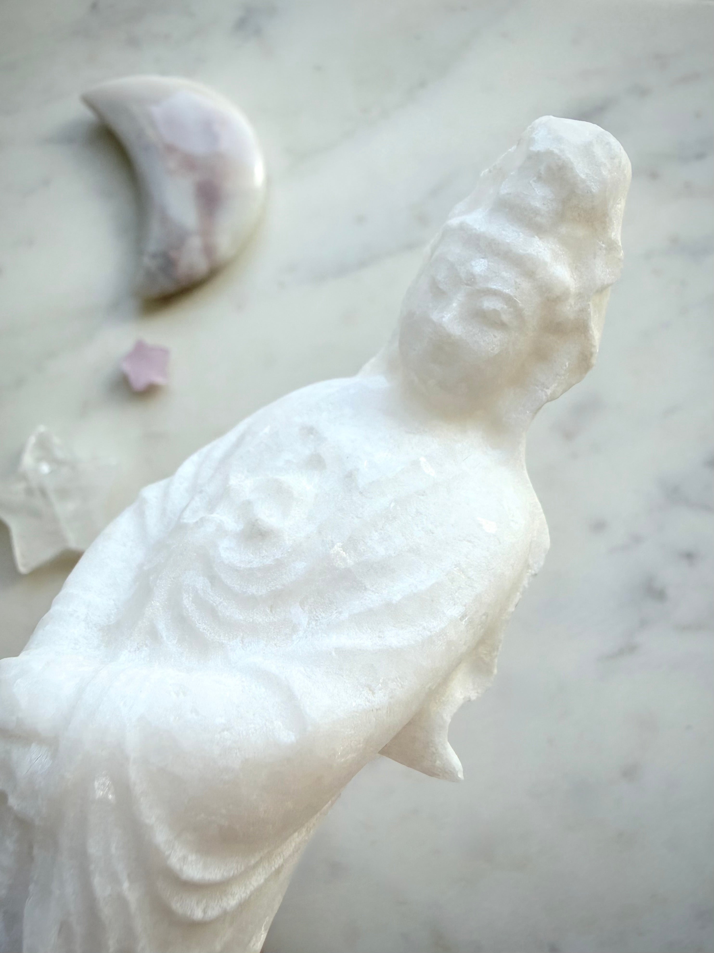 Detailed view of White Jade Goddess of Mercy carving with soft sparkle and elegant drapery
