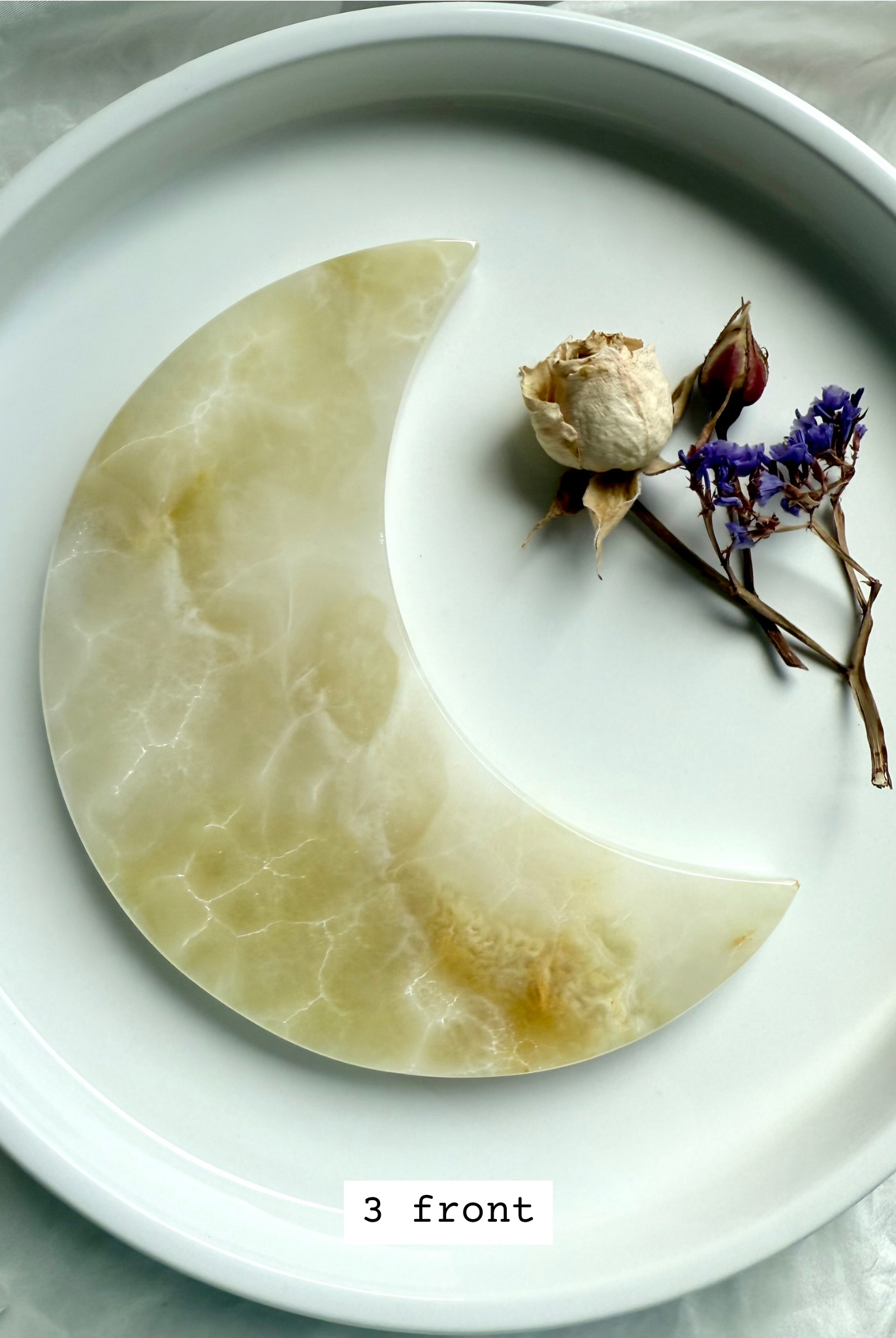 White Onyx Crescent Moon Plate, milky white with natural golden honey swirls, front view.