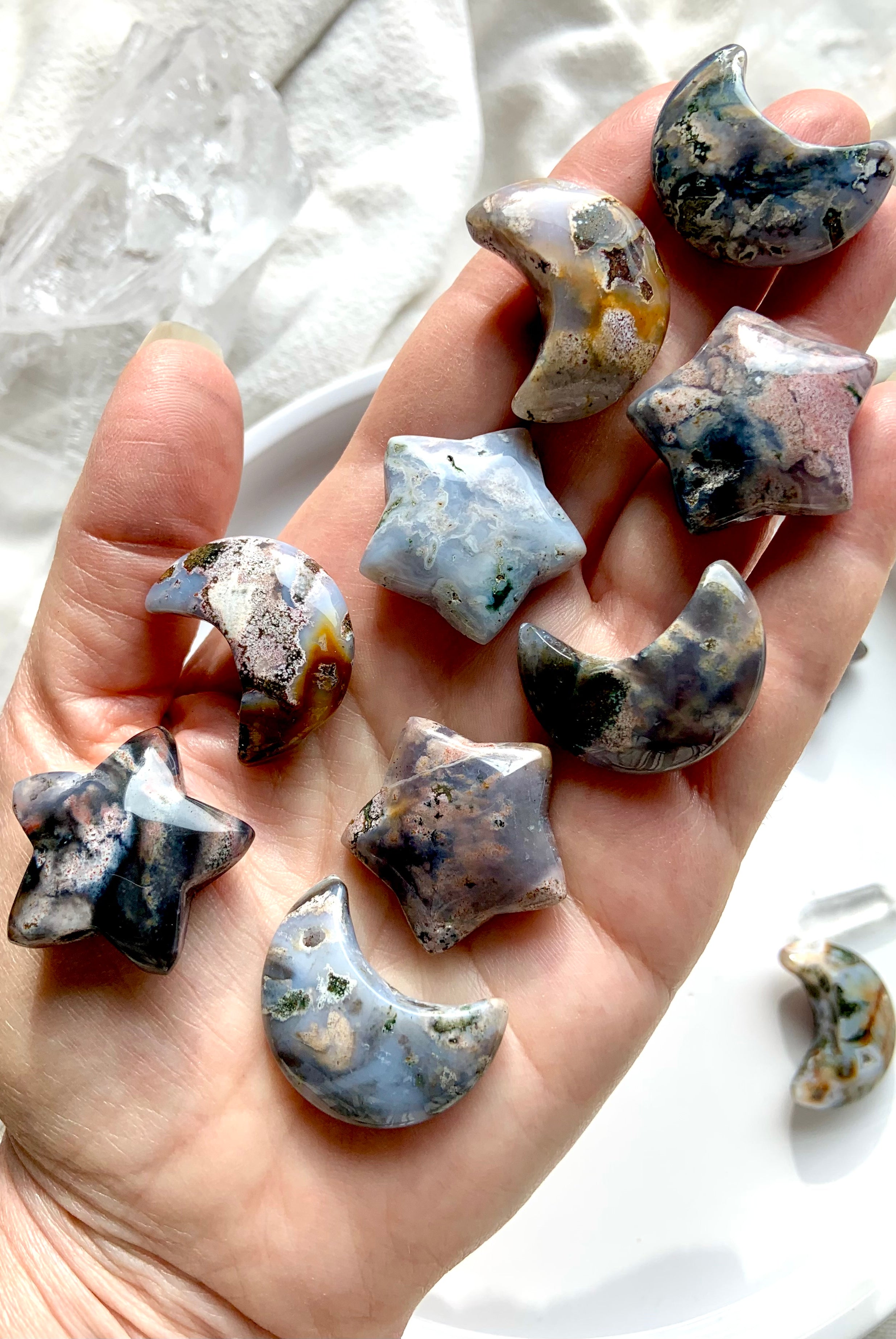 Cosmic Ocean Jasper moons and stars crystal carvings displayed on hand for size reference, grounding and heart chakra healing crystals
