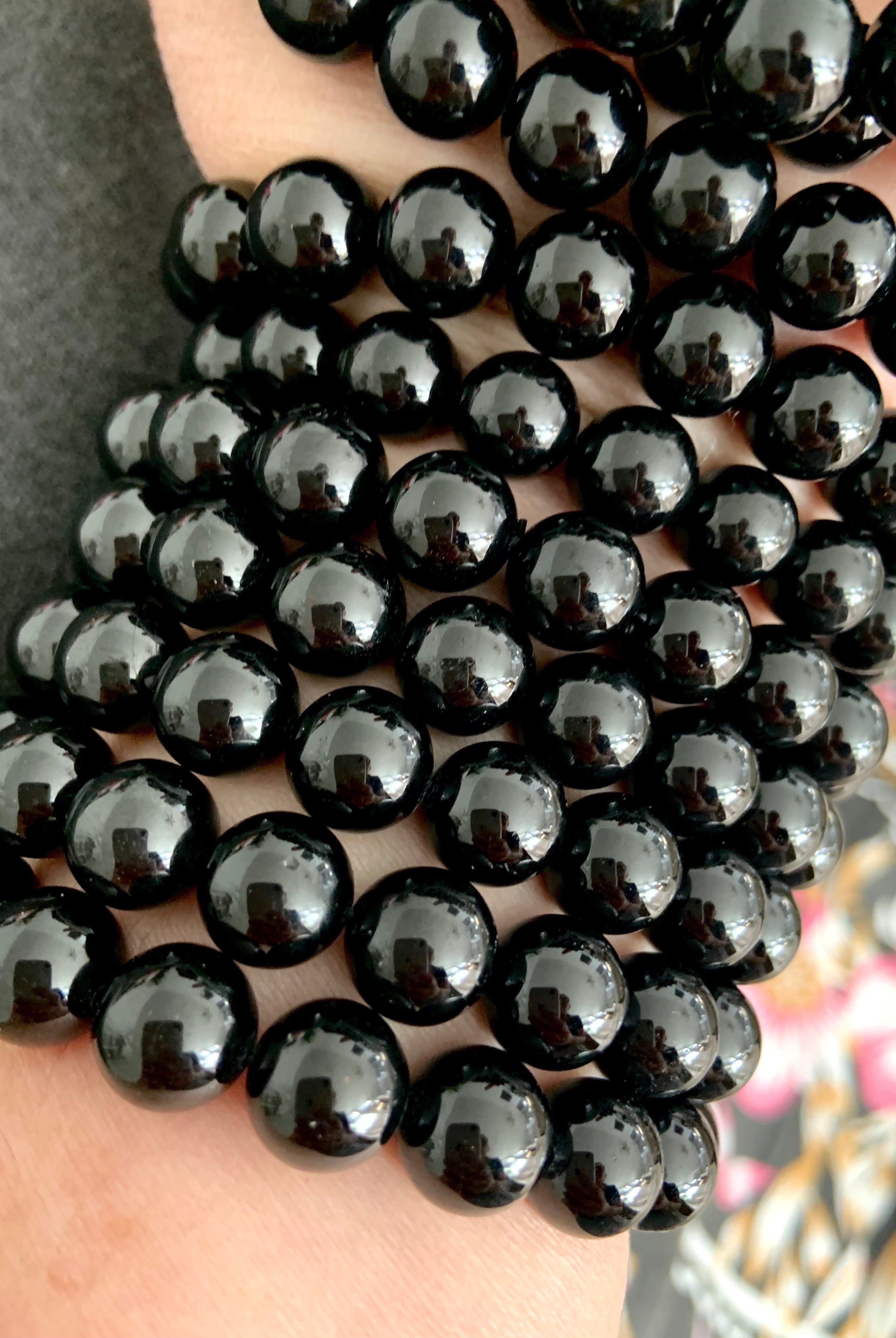 Closeup of a high quality Black Tourmaline bracelet stack with glossy polished beads for energetic protection and grounding