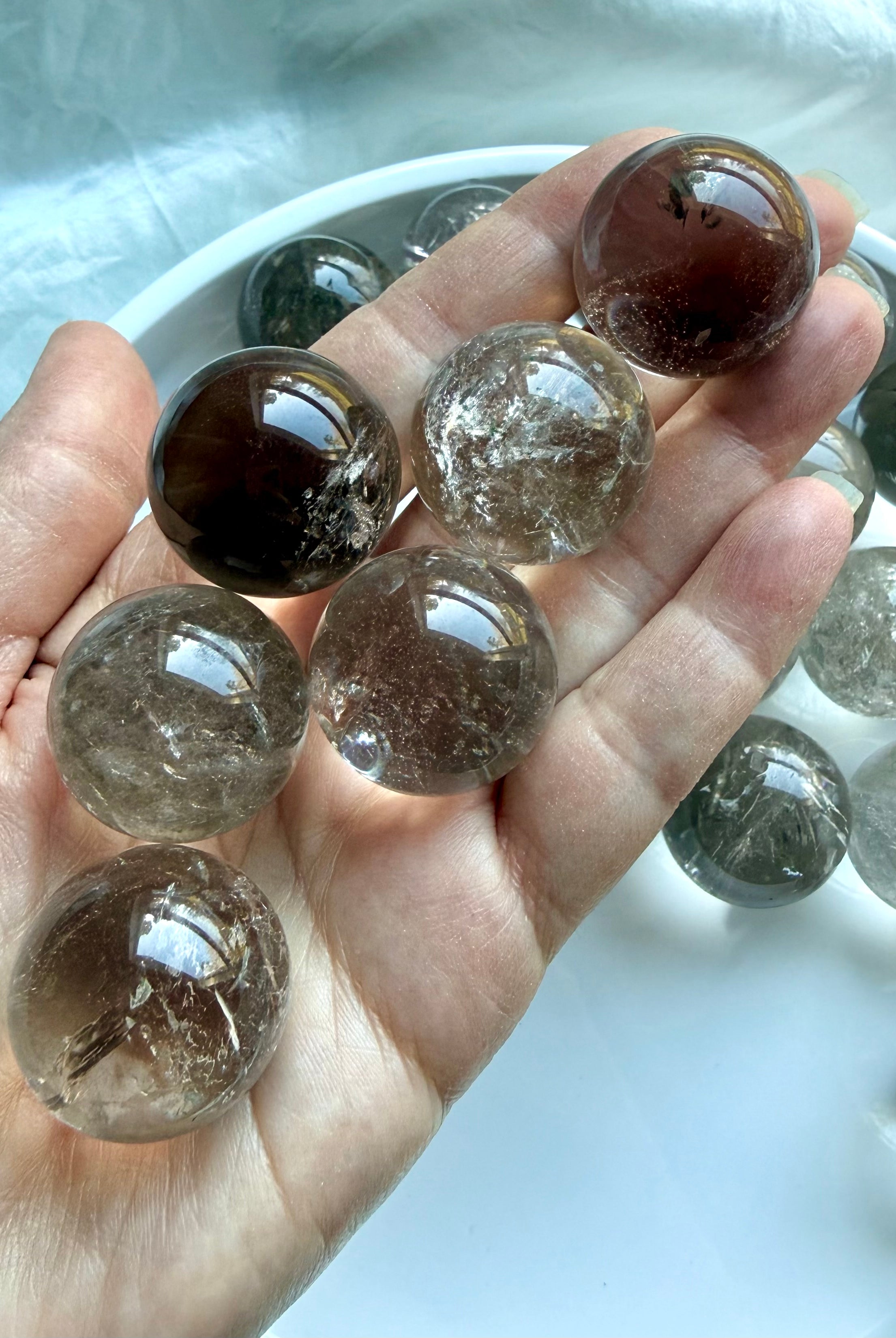 Handheld Smoky Quartz mini crystal spheres with rainbow inclusions and natural smoky transparency