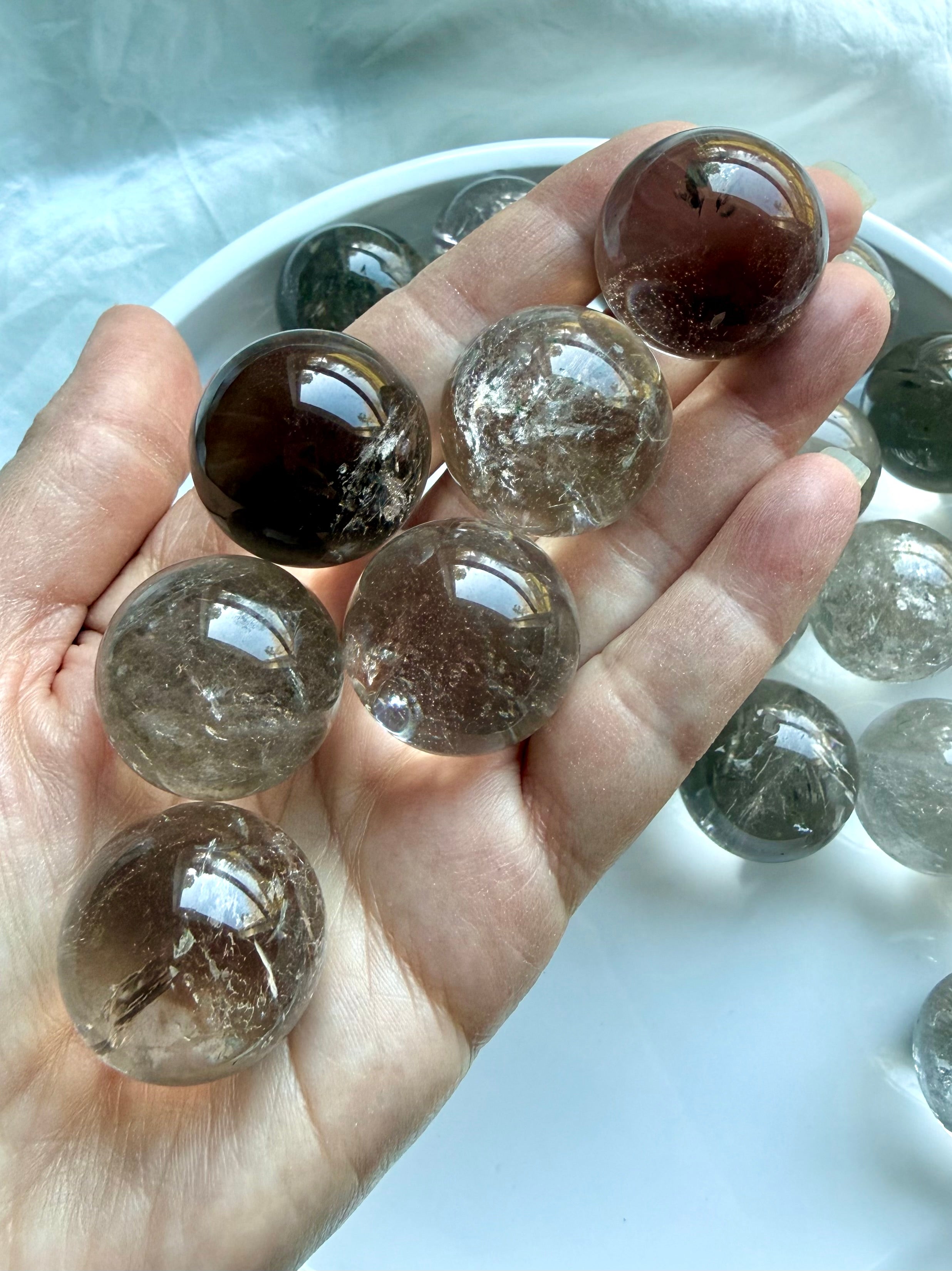 Handheld Smoky Quartz mini crystal spheres with rainbow inclusions and natural smoky transparency