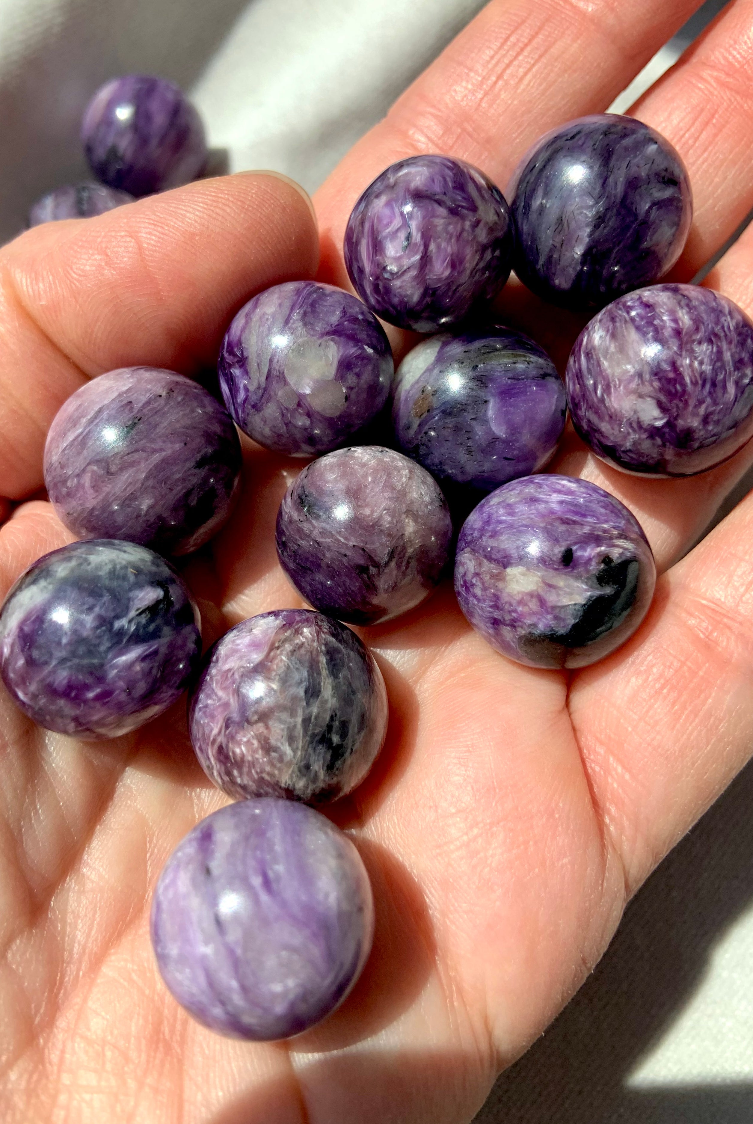 Purple Charoite mini spheres shown on my hand for scale