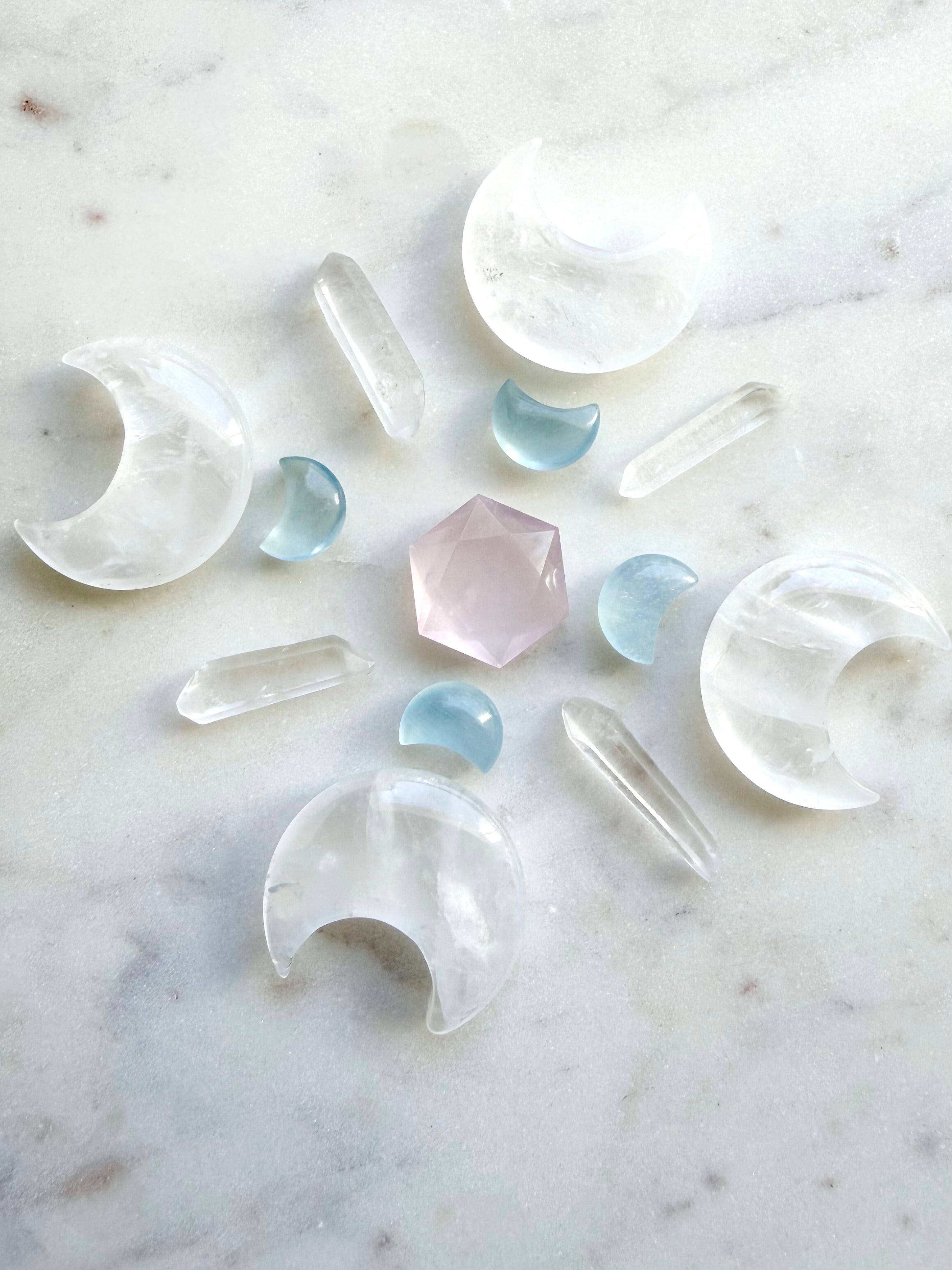 Crystal grid featuring clear quartz moons, quartz points, rose quartz, and aquamarine moon carvings — a layout for peace, clarity, and divine connection.