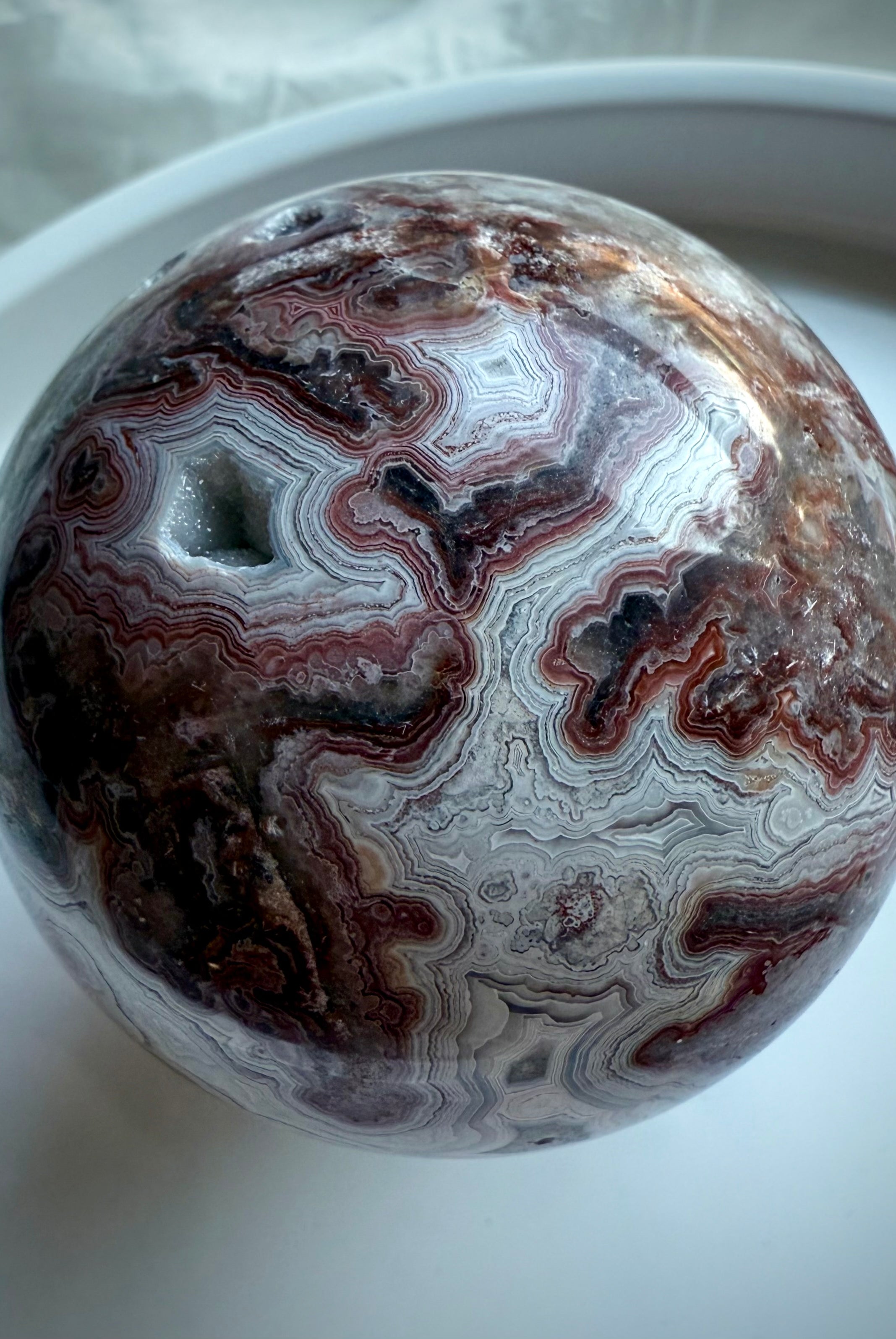Crazy Lace Agate sphere rotated to display natural druzy pocket and joyful, protective Root Chakra vibes