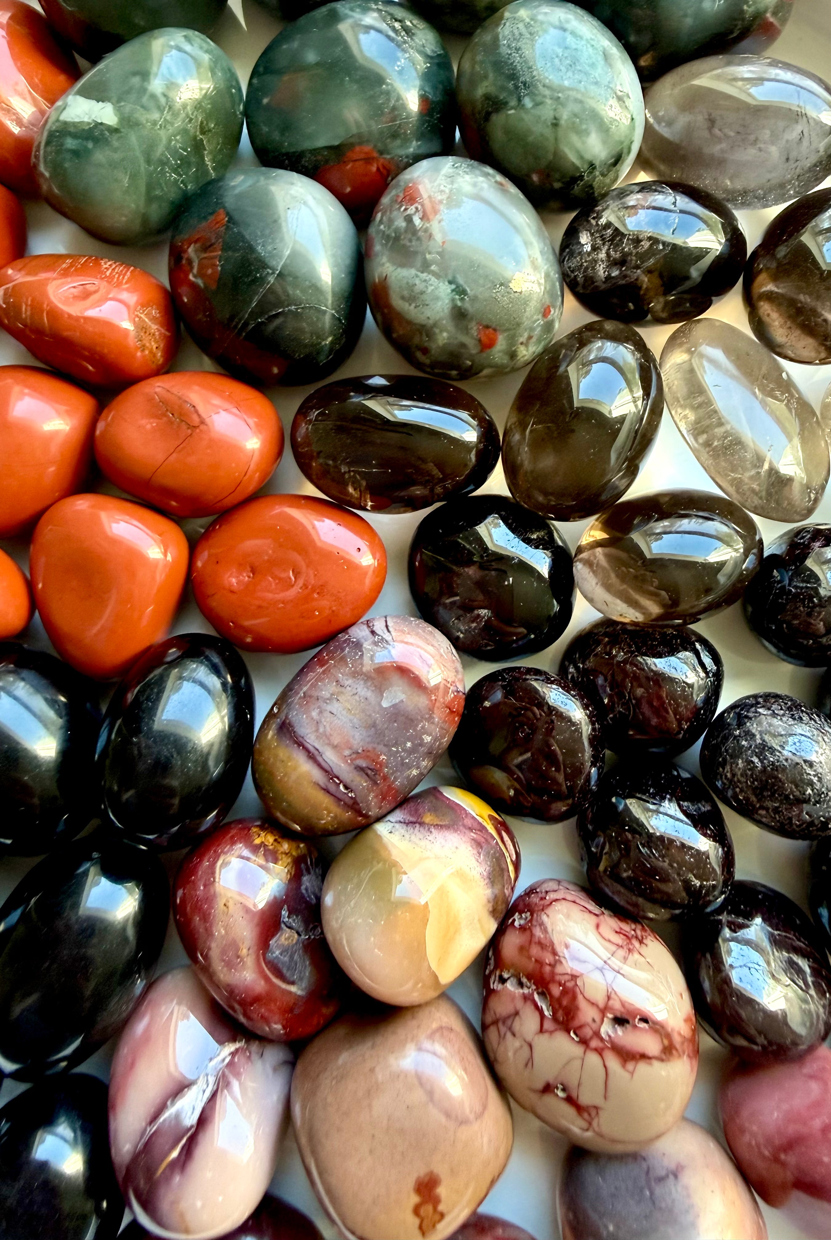 Closeup of Grounding Root Chakra crystals including Bloodstone, Black Obsidian, Red Jasper, Smoky Quartz, Garnet, and Mookaite Jasper