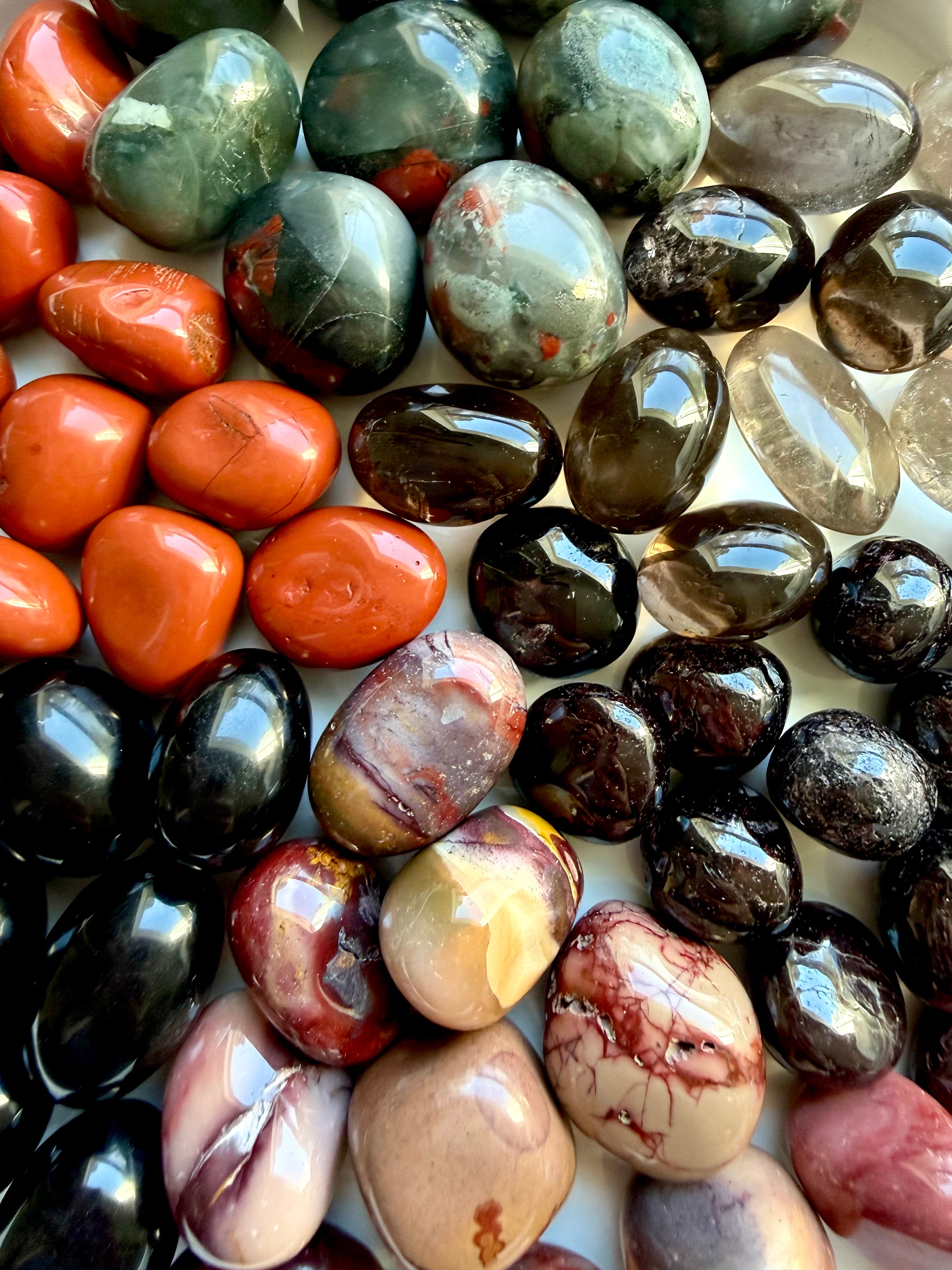 Closeup of Grounding Root Chakra crystals including Bloodstone, Black Obsidian, Red Jasper, Smoky Quartz, Garnet, and Mookaite Jasper