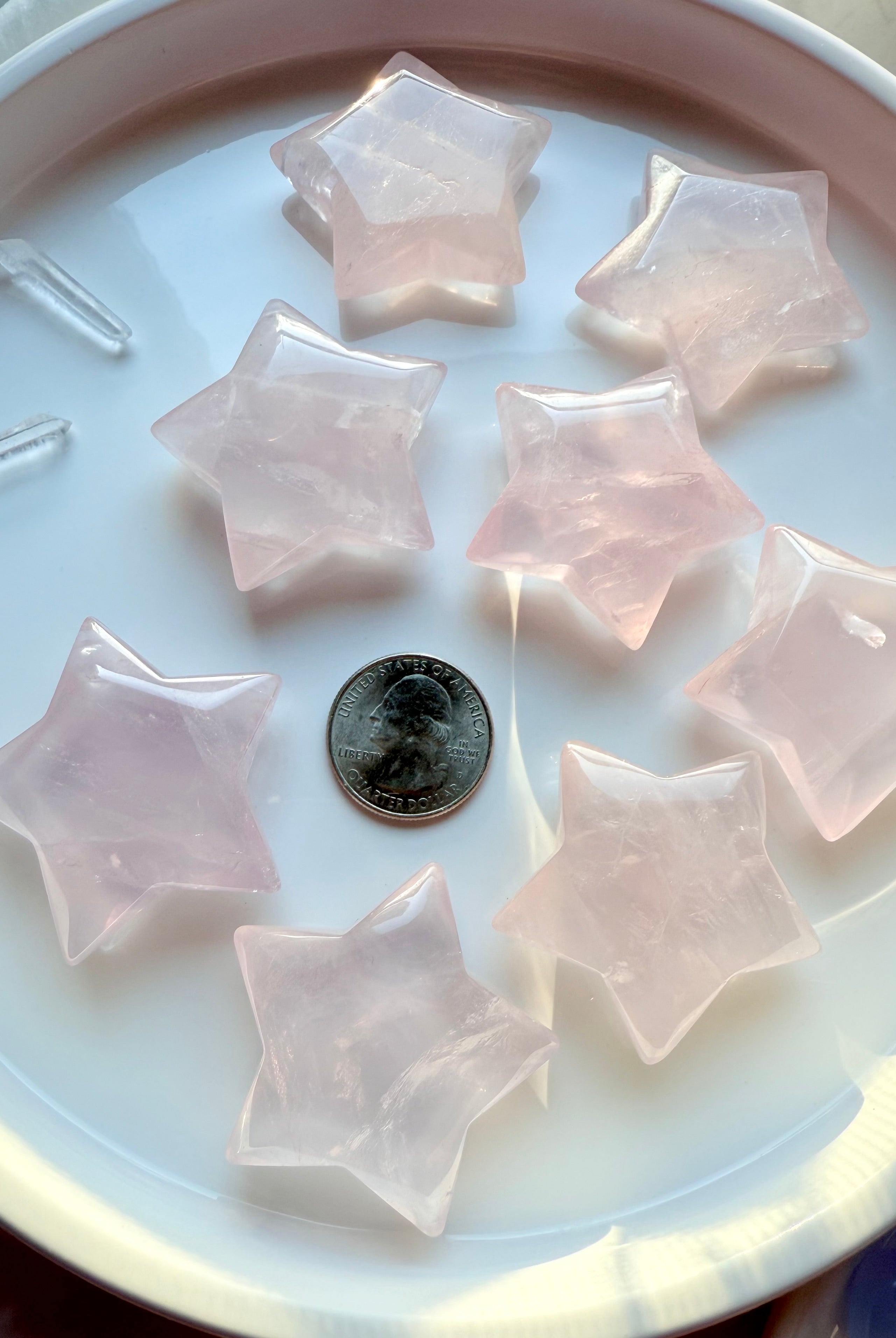 Group of large Mozambique Rose Quartz Stars with a US quarter for scale— hand-carved pink crystal star shapes for love, harmony, and sacred space décor.