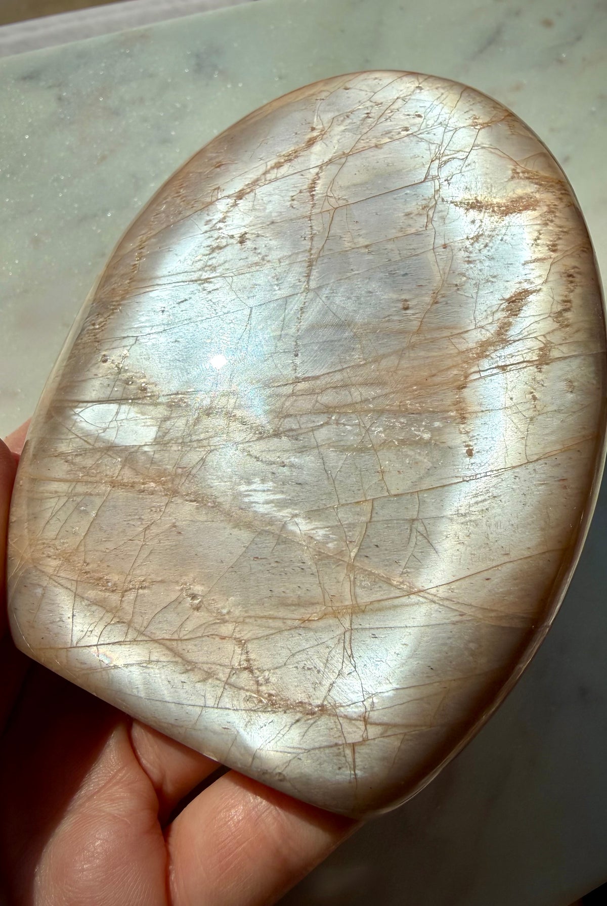 Large Peach Moonstone freeform with reflective silver flash and natural feldspar character visible in angled lighting