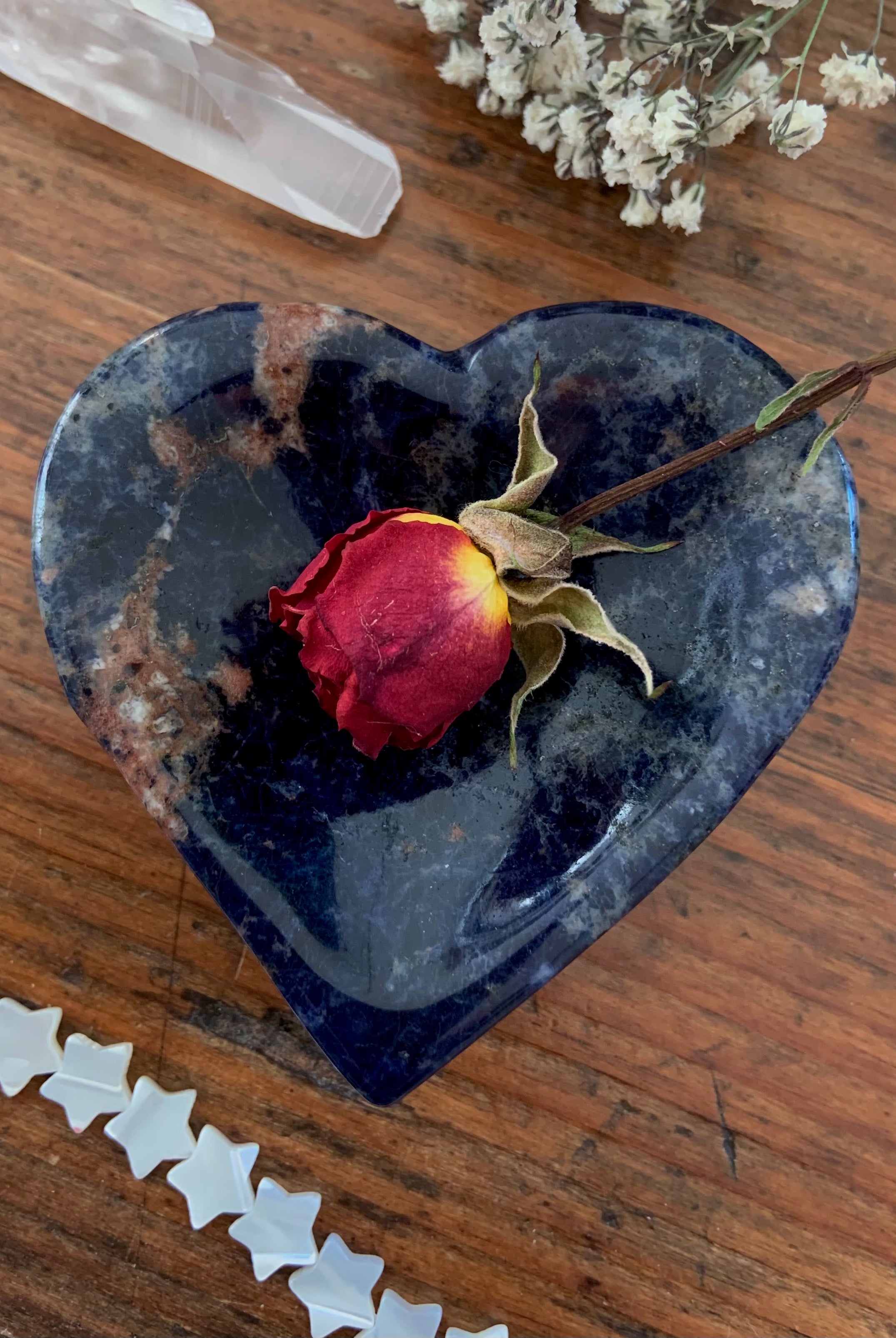 Hand carved blue Sodalite Heart Bowl or stone ring dish. Picture shows a red rose inside.