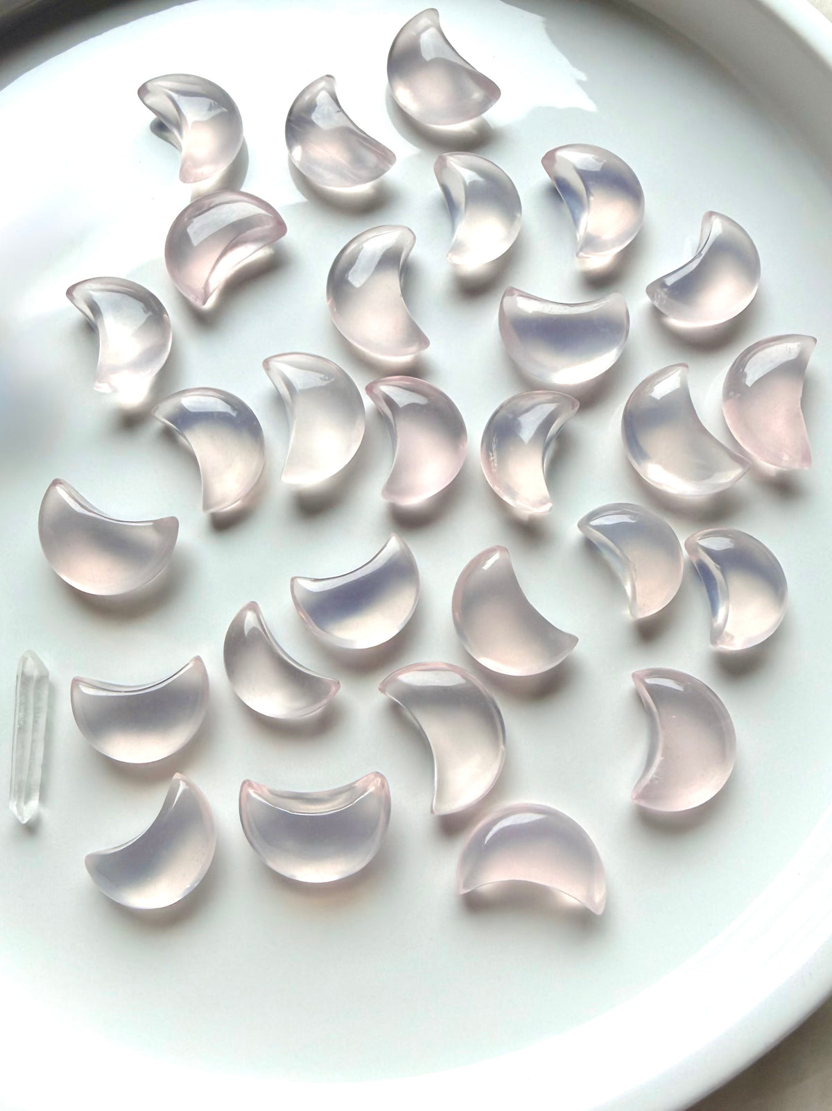 Mini Rose Quartz moons arranged on a white dish, small crystal carvings for love and Heart Chakra healing