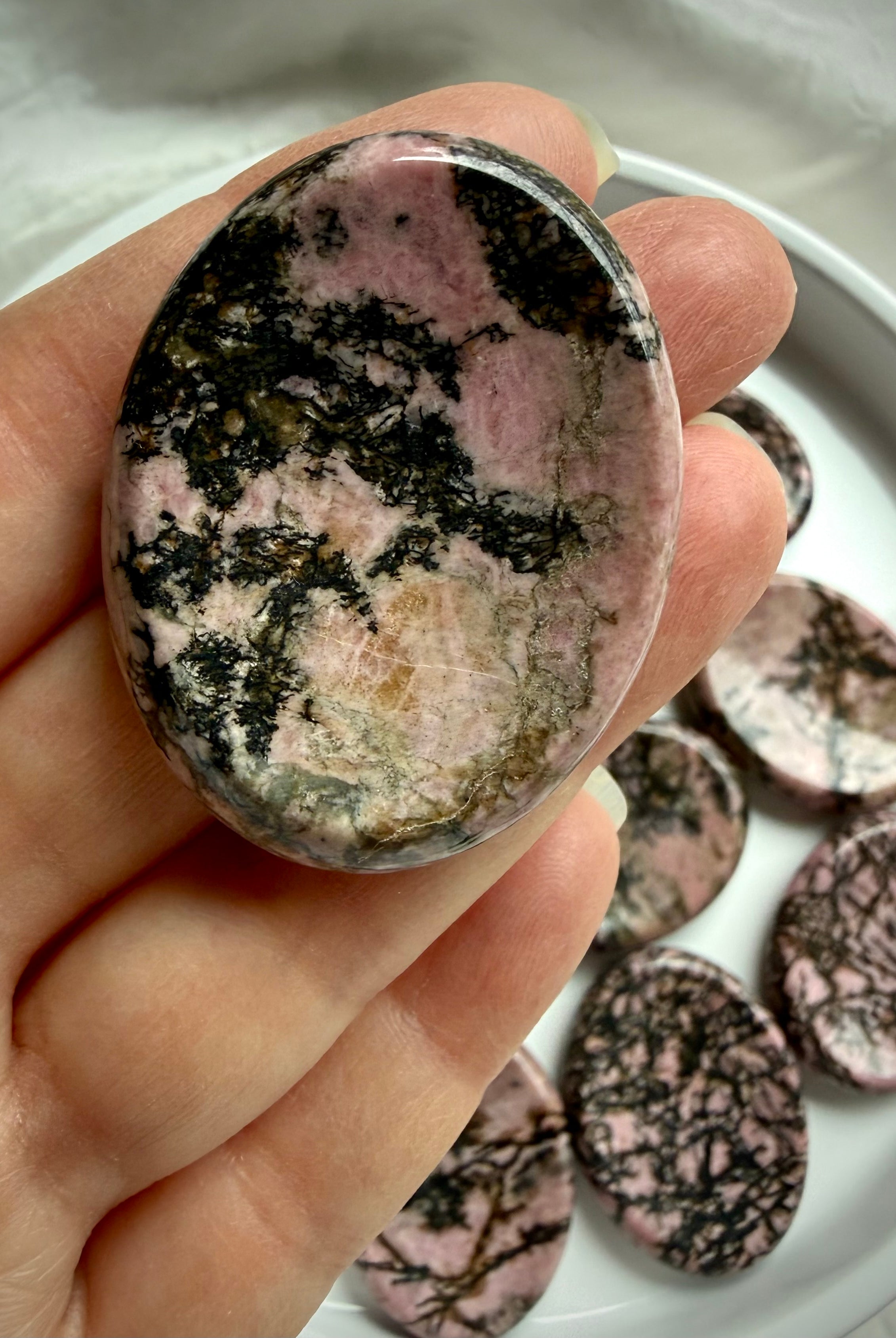 Oval Rhodonite worry stone with pink, tan and black matrix