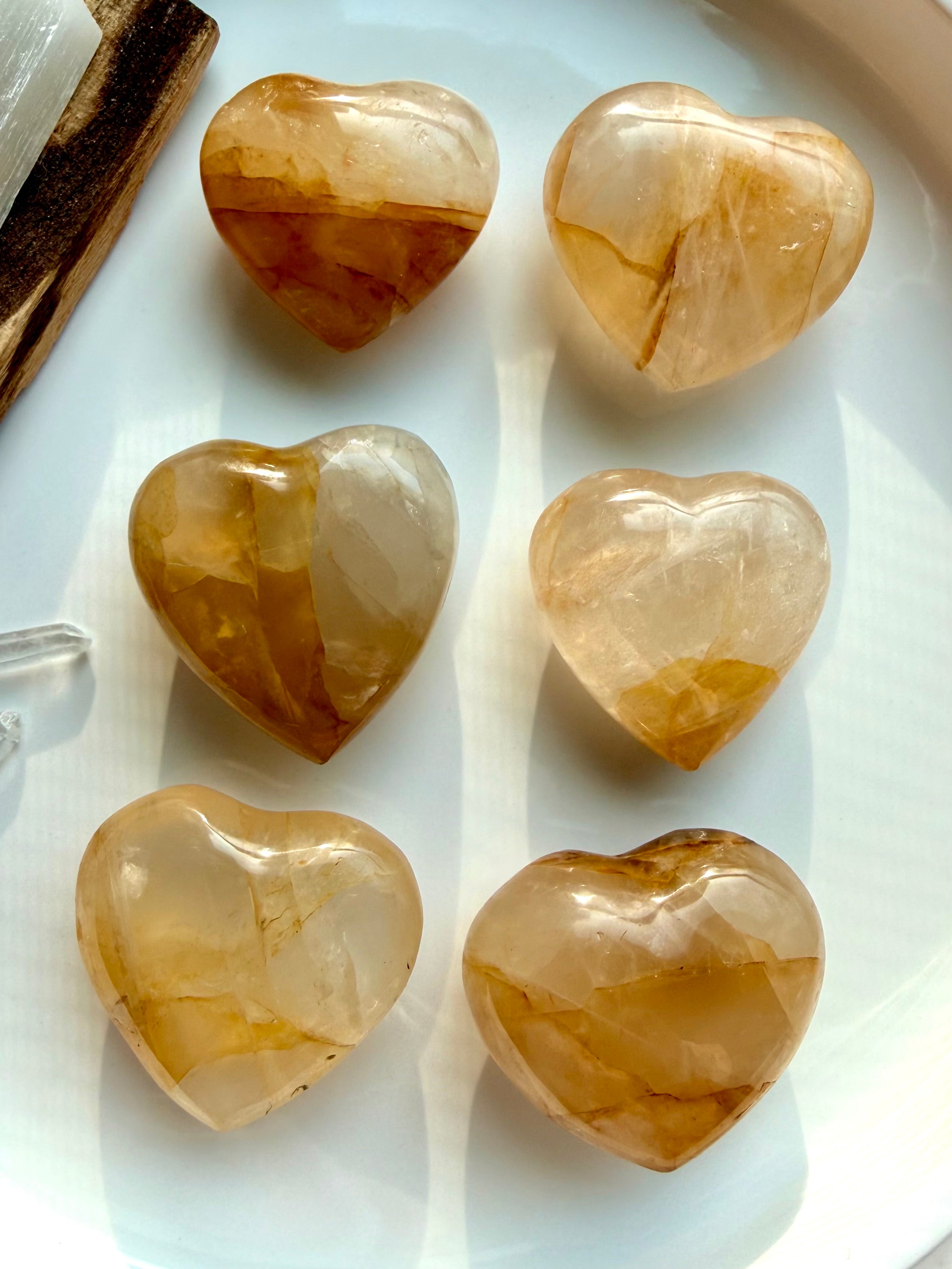 golden healer quartz heart carvings displaying variation in golden hues translucency and patterning