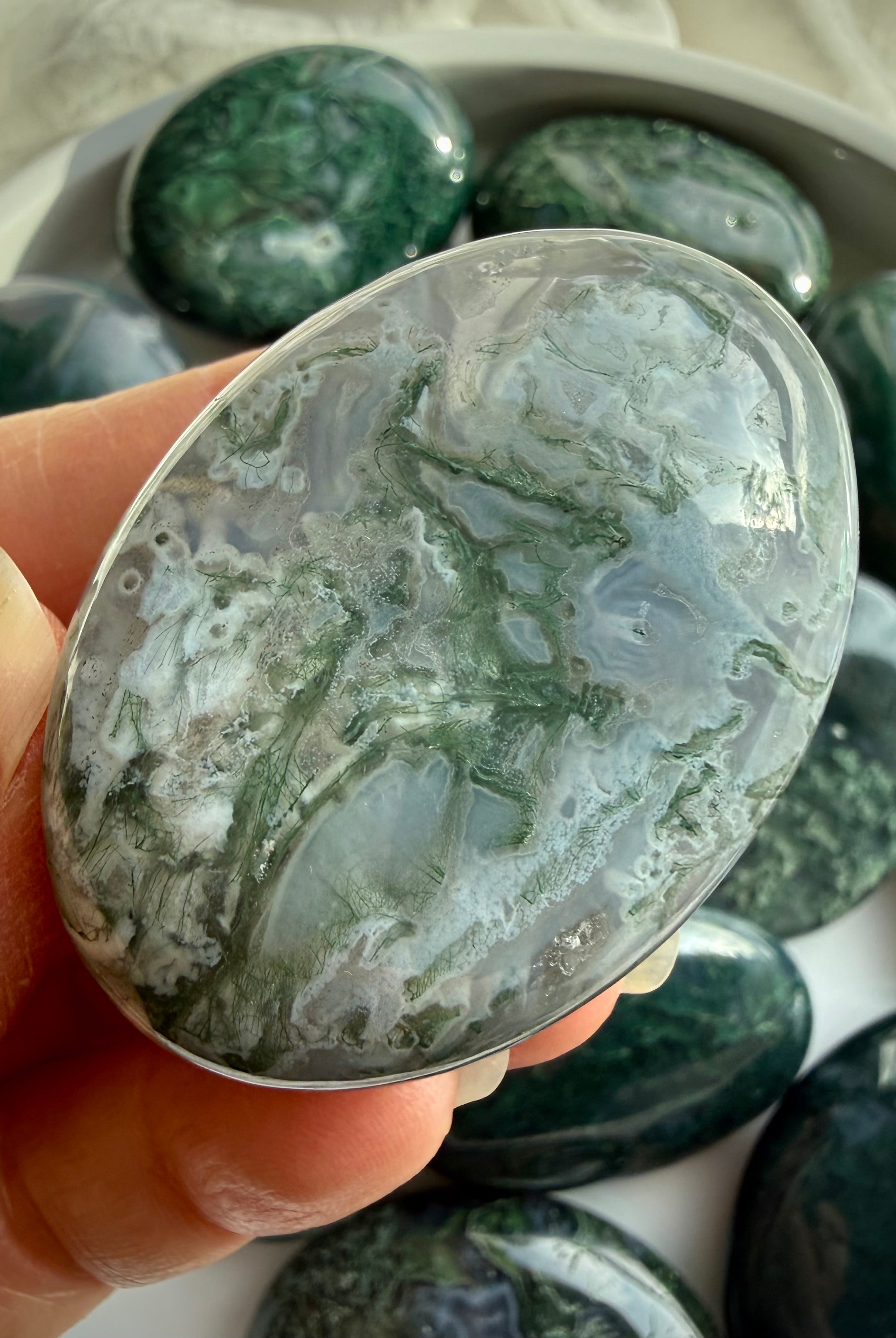 Moss agate palm stone close view showing smooth polish and comfortable palm stone shape for meditation and grounding