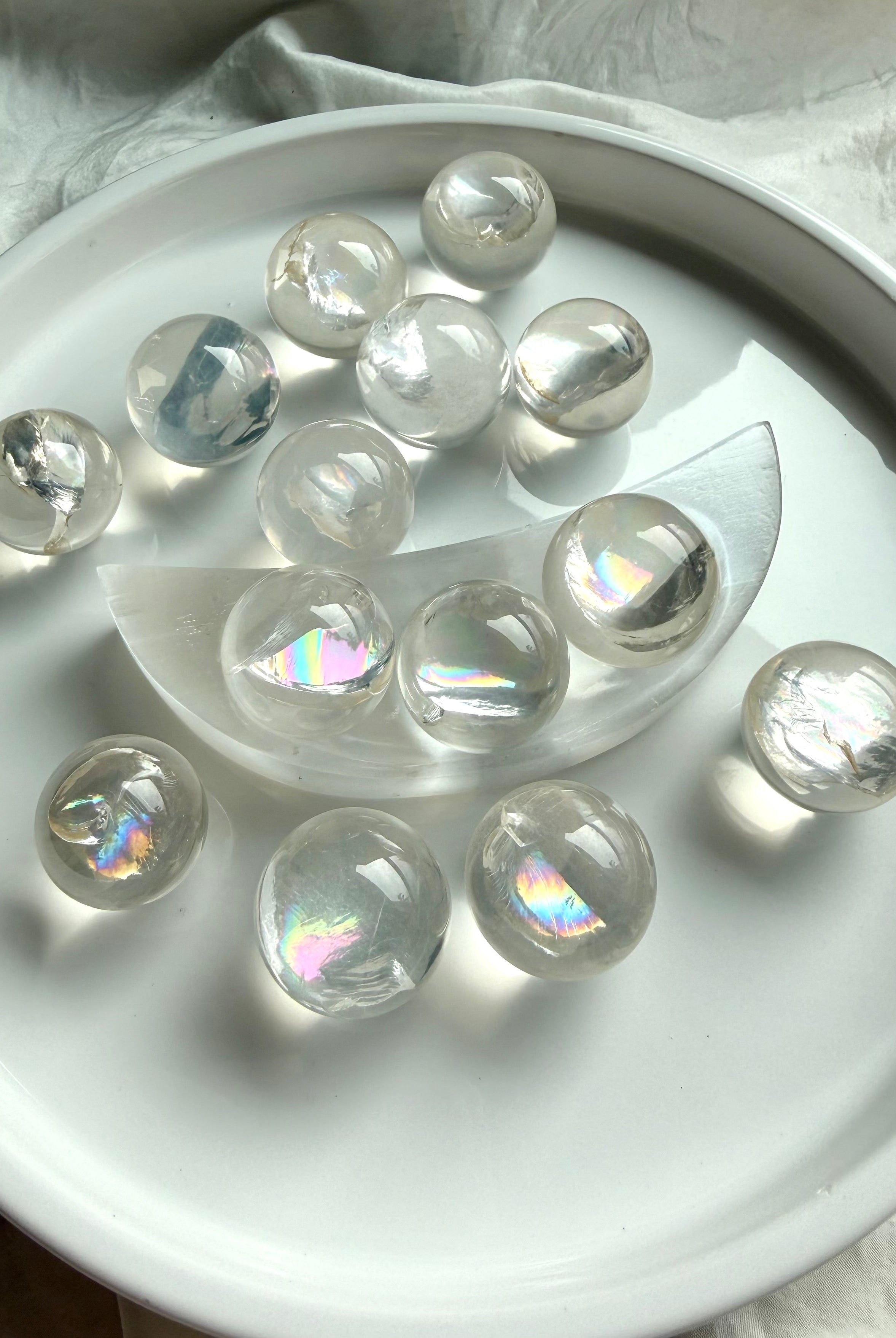 Collection of rainbow girasol mini quartz crystal spheres with luminous milky translucence and soft mystical glow