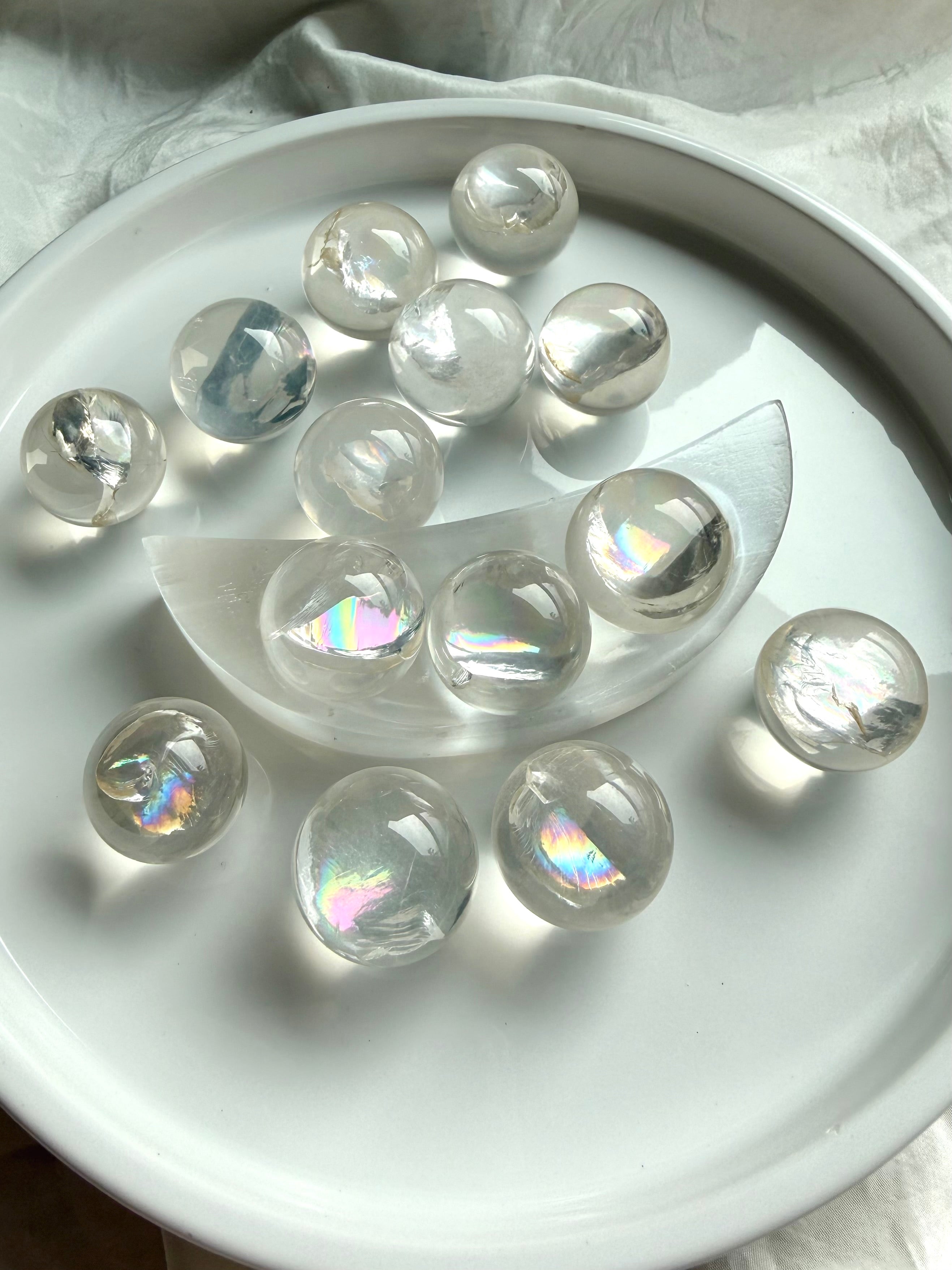 Collection of rainbow girasol mini quartz crystal spheres with luminous milky translucence and soft mystical glow