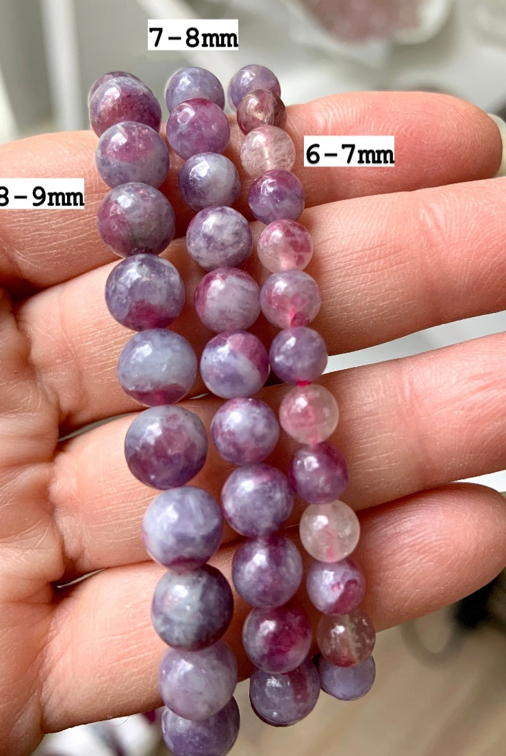 Comparison of Unicorn Stone bracelets in 6–7mm, 7–8mm, and 8–9mm bead sizes — Pink Tourmaline in Lepidolite crystal bracelets shown on hand with size markers for reference.