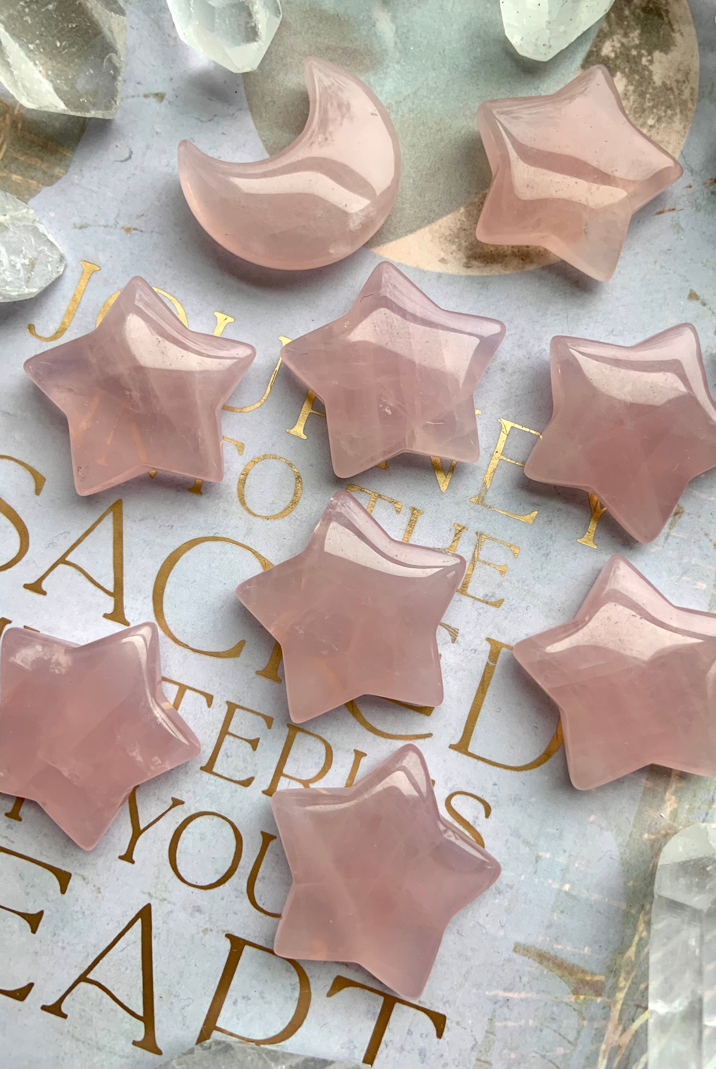Small rose quartz star carvings on a pale lilac journal with gold text. Heart Chakra crystals for peace, calm, & emotional healing.