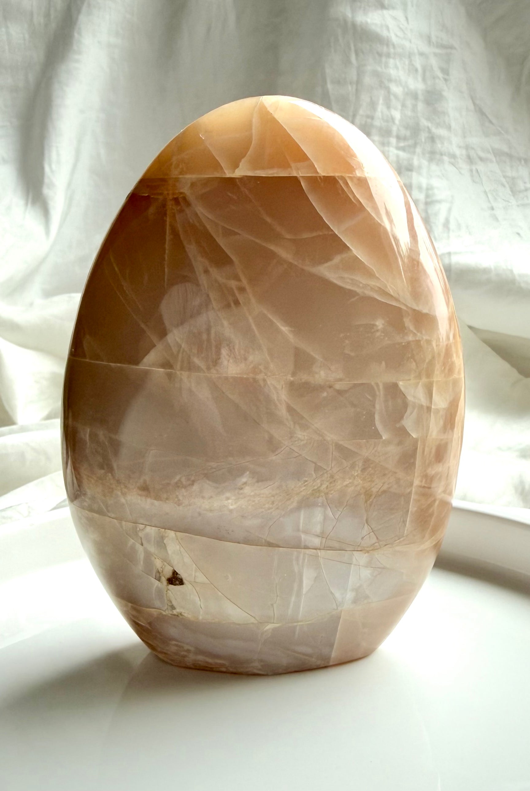 Peach Moonstone crystal freeform with glowing flash and natural moonstone patterning in a standing display