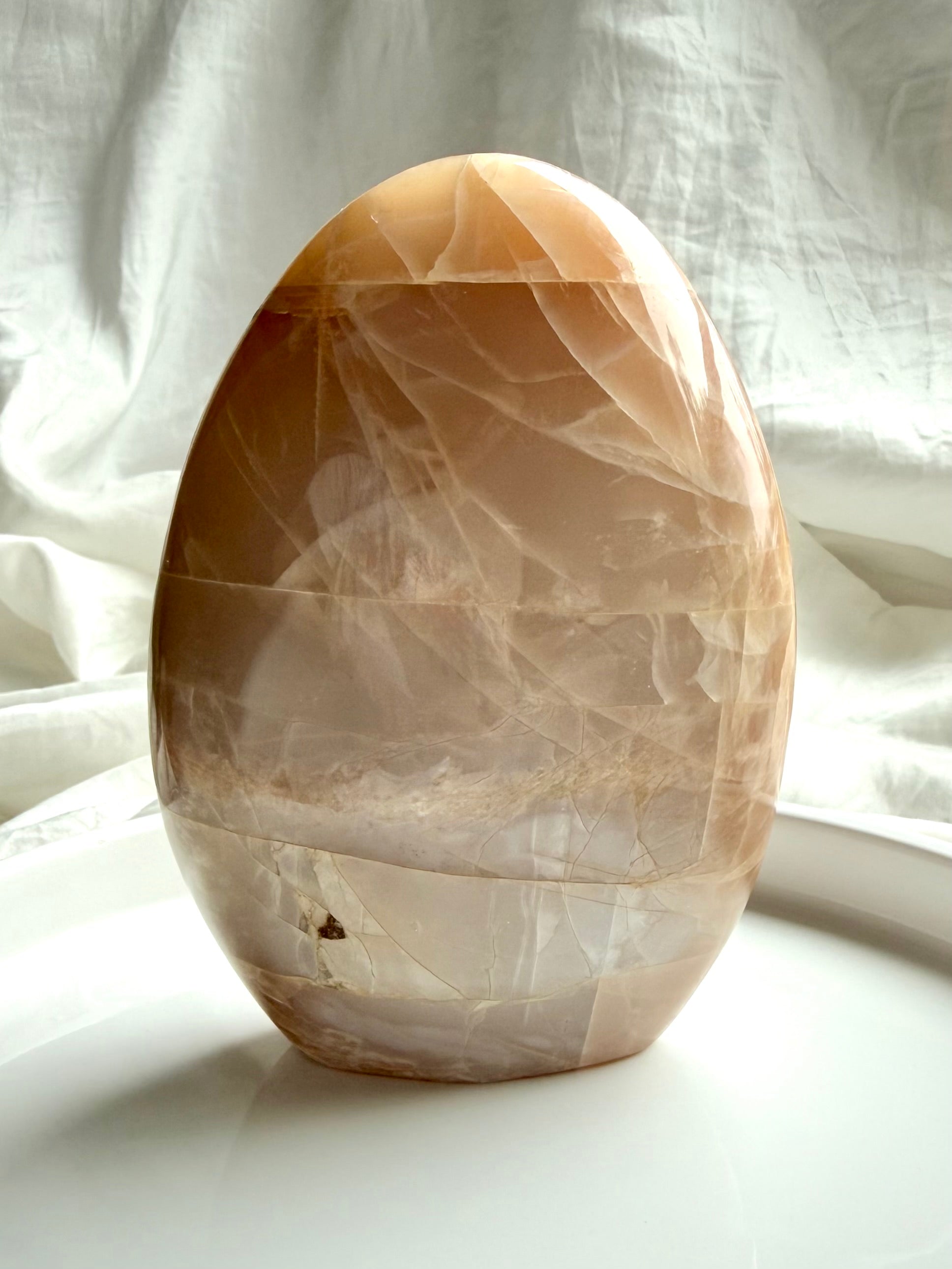 Peach Moonstone crystal freeform with glowing flash and natural moonstone patterning in a standing display
