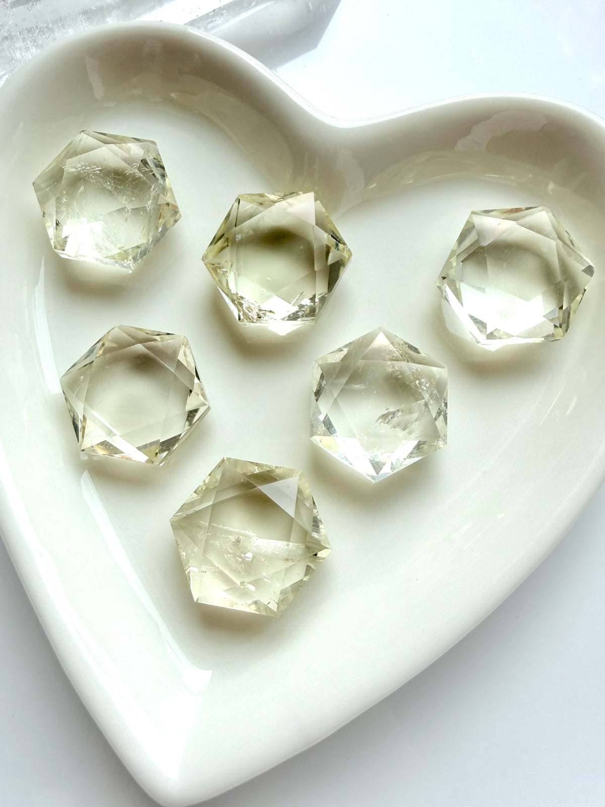 Faceted Citrine crystals in hexagon shapes with luminous champagne-gold color and reflective precision-cut facets
