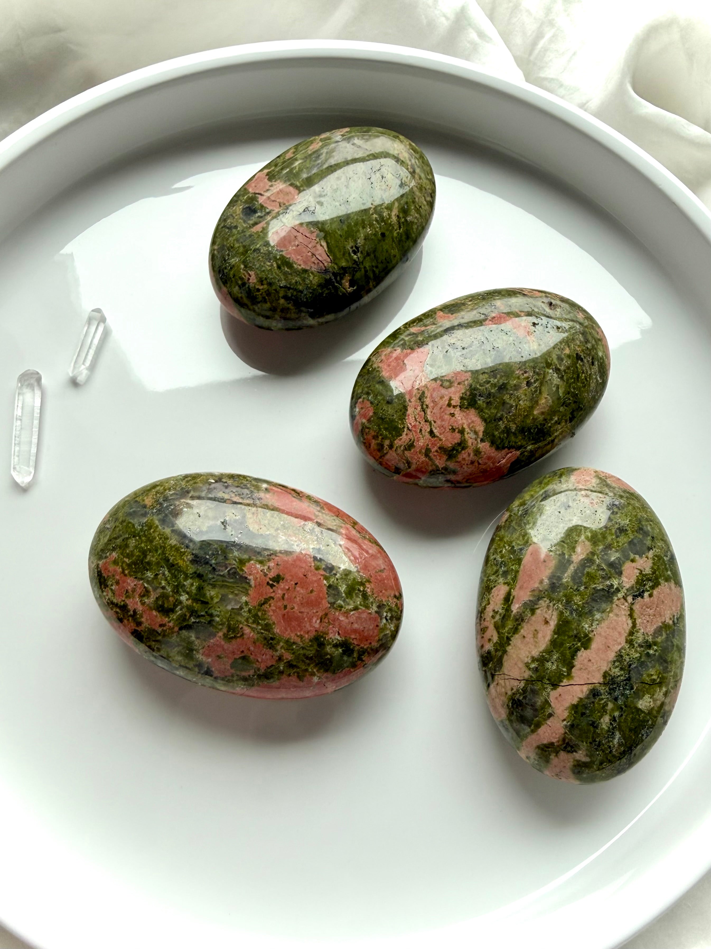 set of Unakite palm stones on tray polished healing crystals for heart chakra love balance and grounding