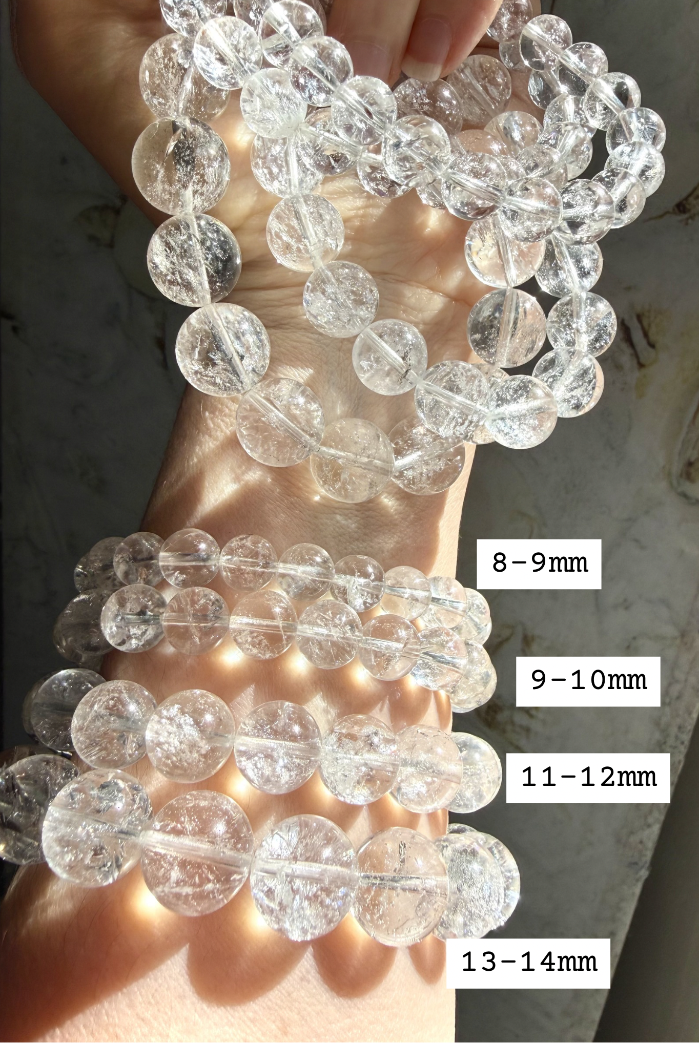 High clarity Clear Quartz bracelet stack shown bead sizes marked 8-14mm for comparison, and iridescent rainbow reflections